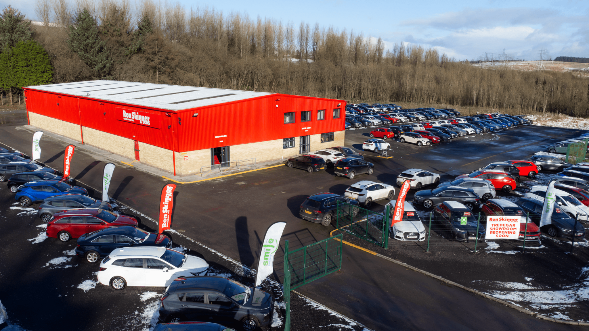 The new Ron Skinner showroom in Tredegar with red sides and cars on the forecourt.  Snow can be seen in places.