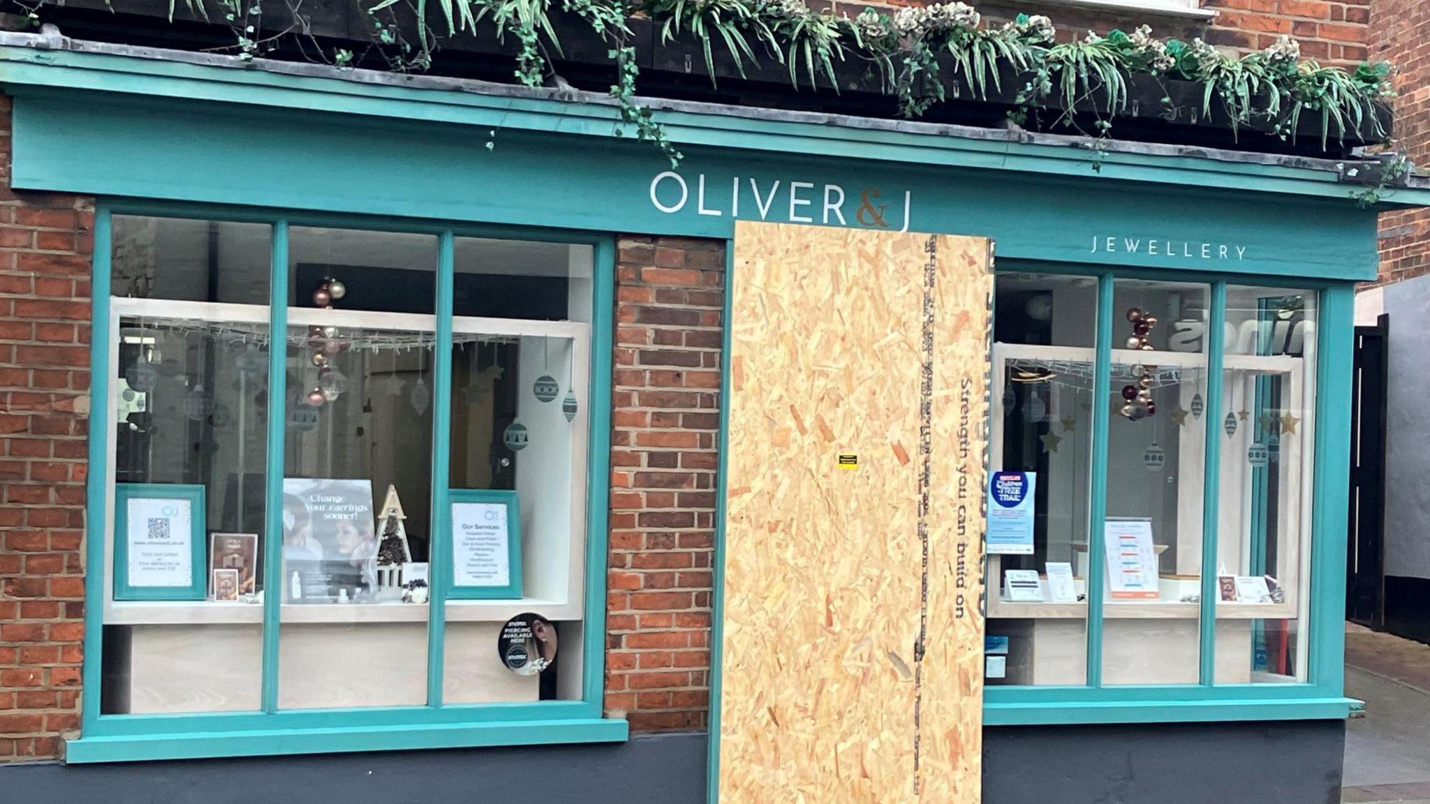 Exterior of a shop which is painted a turquoise blue.
