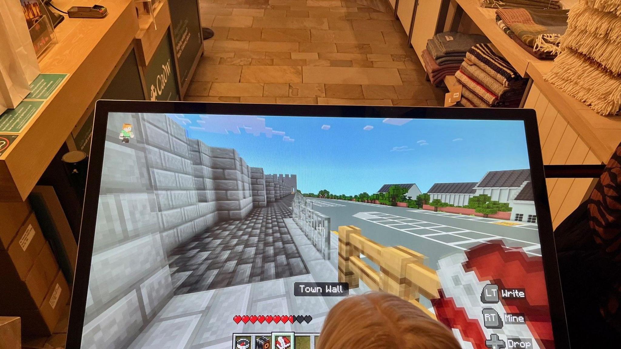  A child looks at the game on a TV screen as she plays the game.