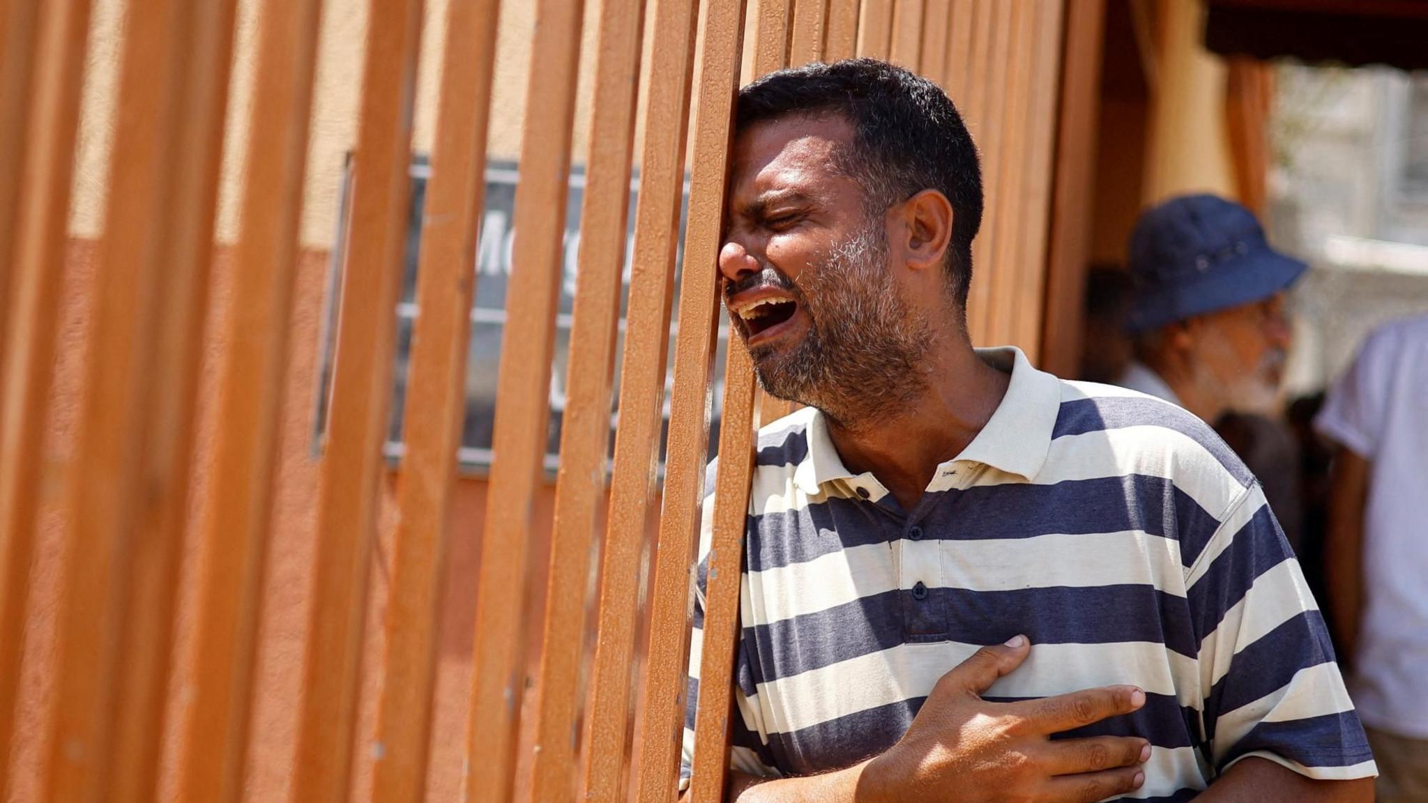 A man cries during the funeral of a Palestinian reportedly killed in an Israeli strike, at Nasser hospital in Khan Younis, in the southern Gaza Strip (22 July 2024)