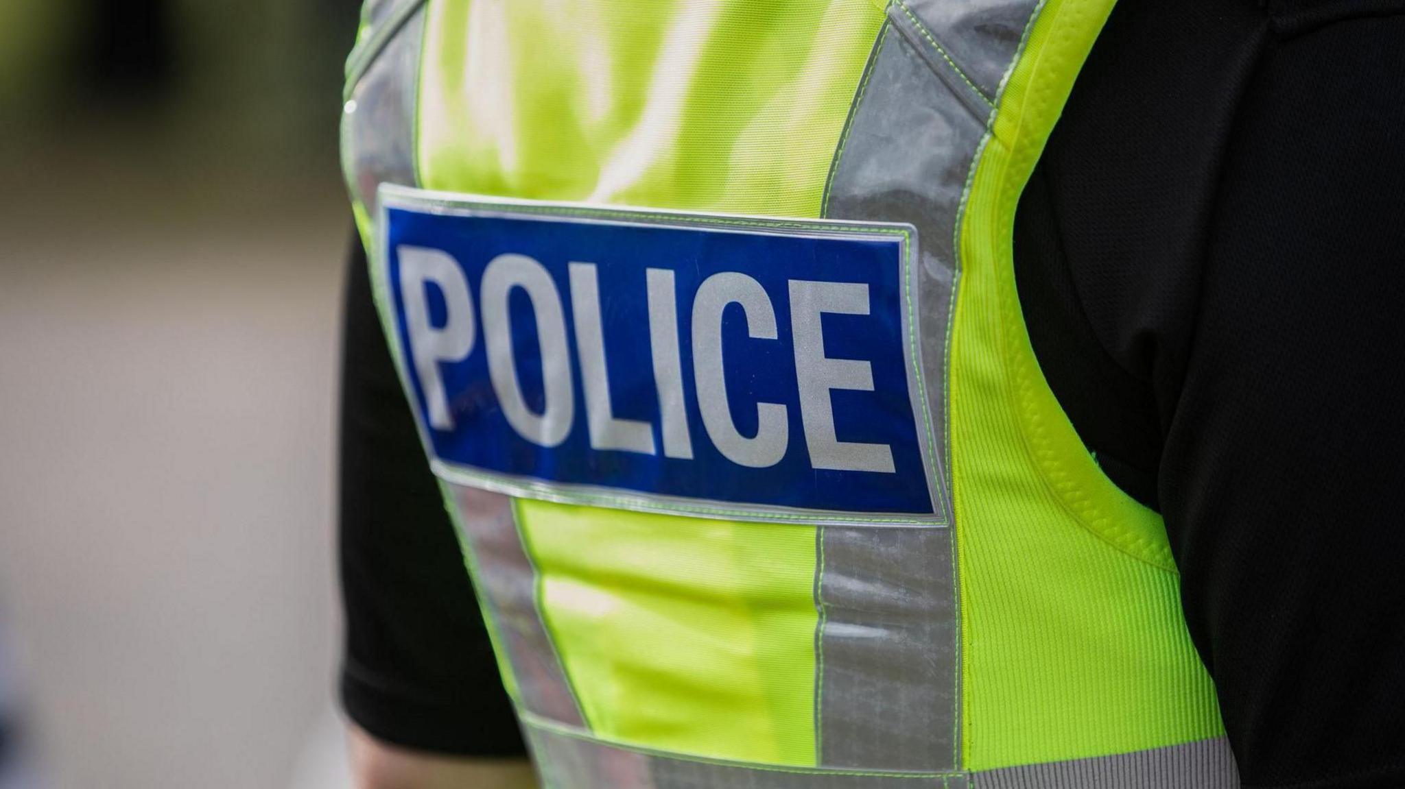 The back of a police officer wearing a Hi Vis  jacket