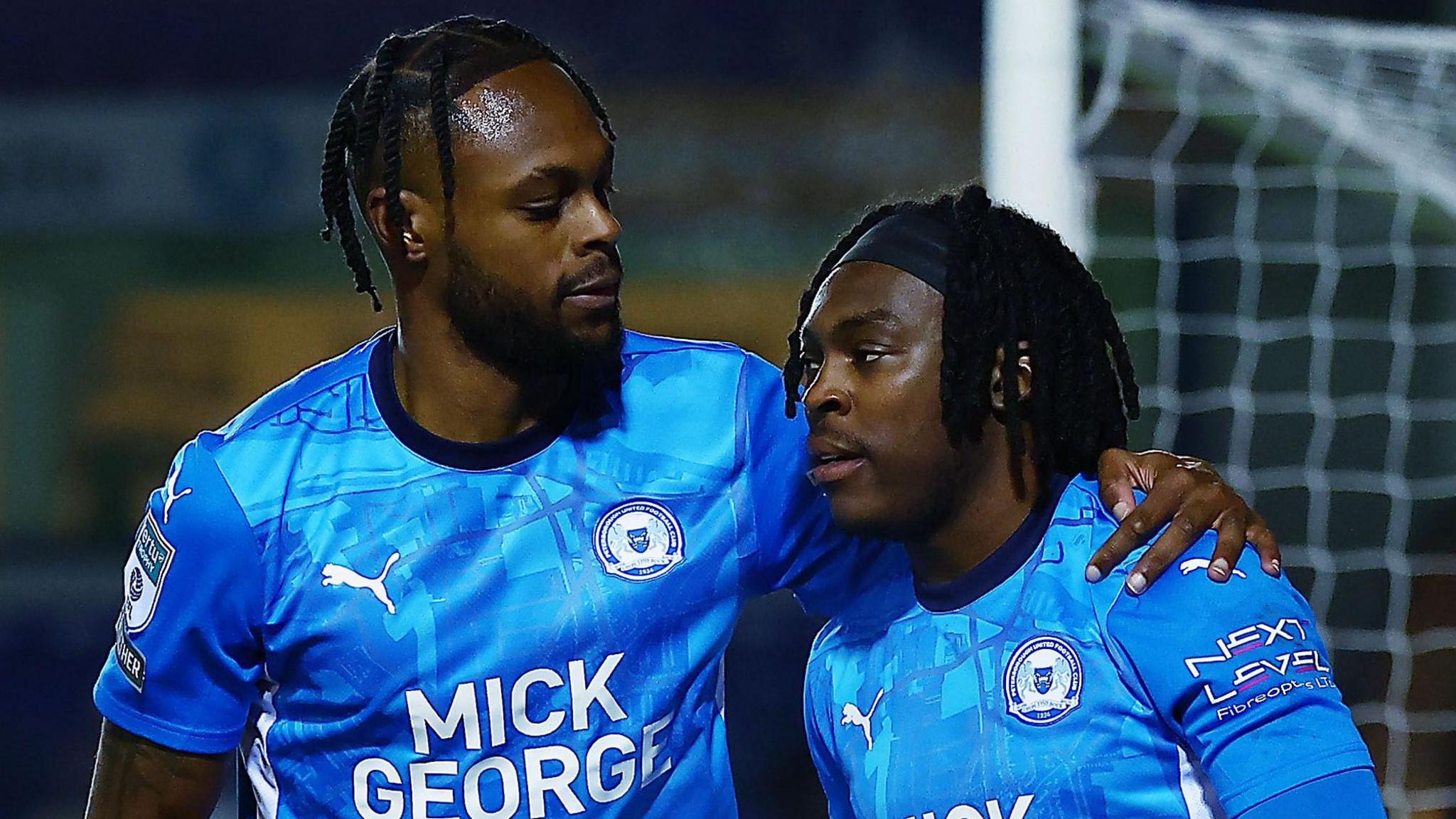 Ricky Jade-Jones congratulates Peterborough United team-mate Abraham Odoh following his goal against Cheltenham Town