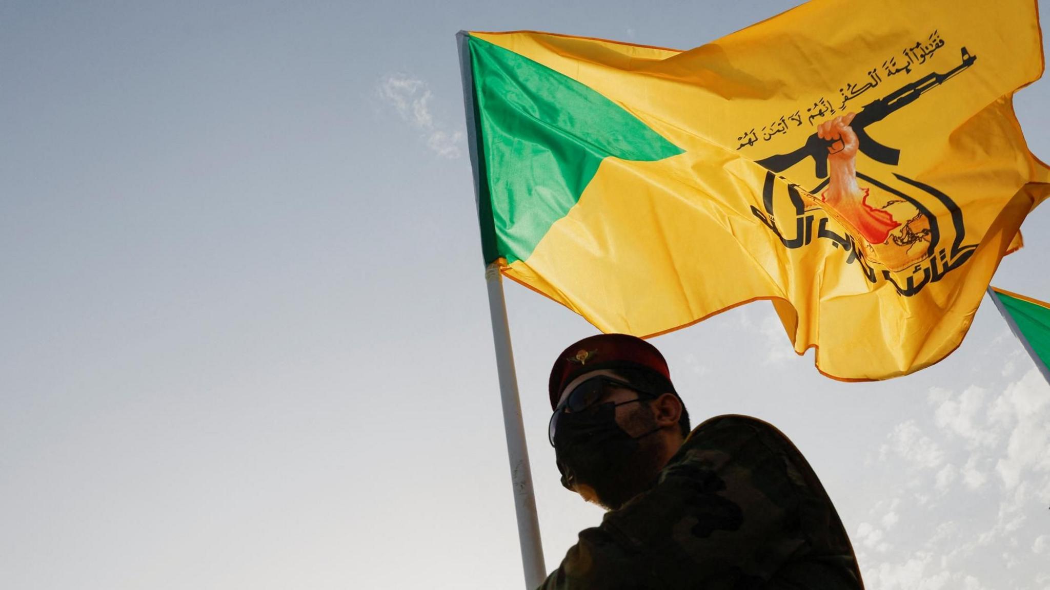File photo showing a mourner carrying a Kataib Hezbollah flag during a funeral in Baghdad, Iraq, for a commander of the Iraqi militia who was killed in an Israeli strike in Syria (22 September 2024)