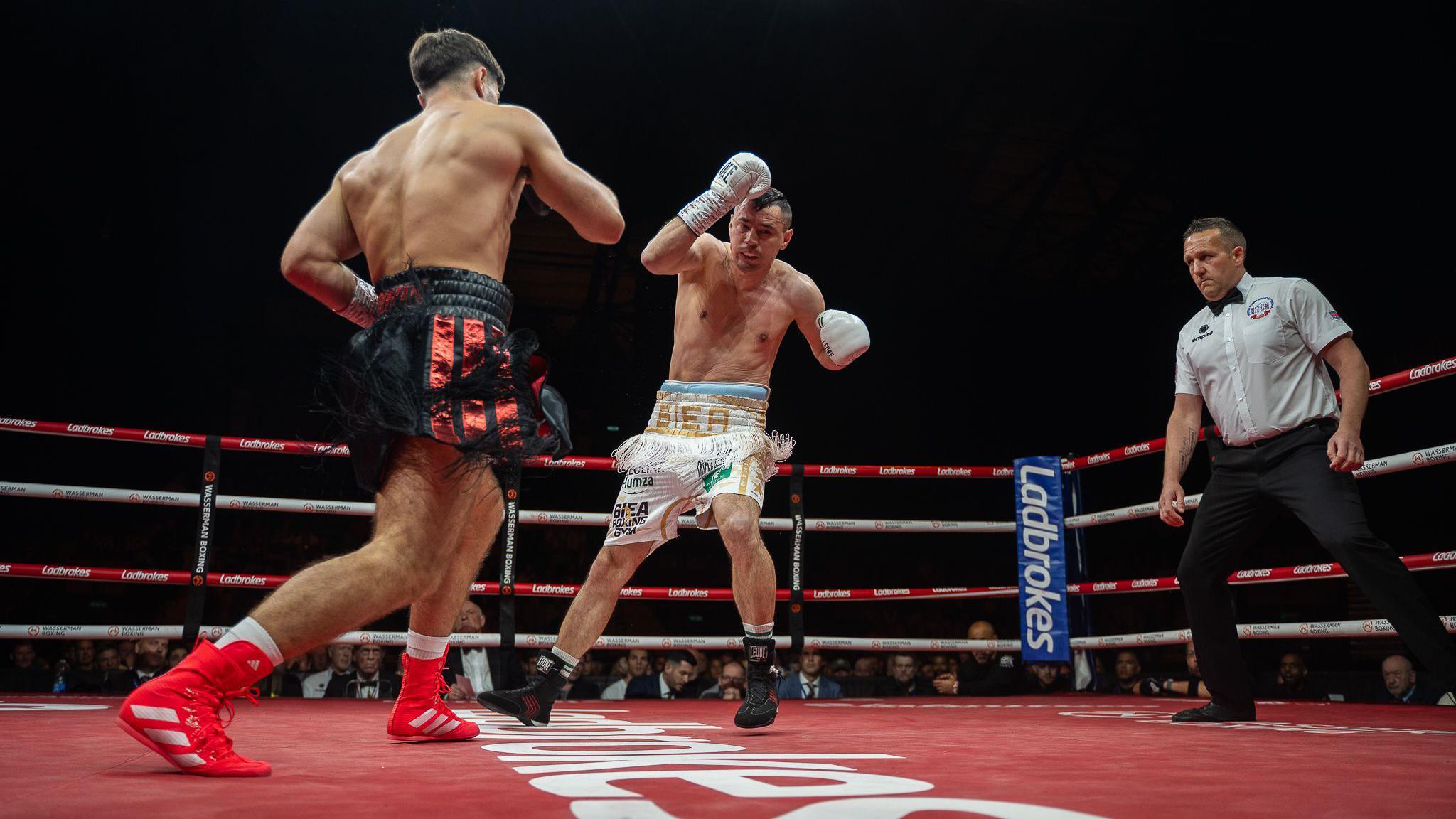 Josh Kelly advances as he knocks down Flavius Biea