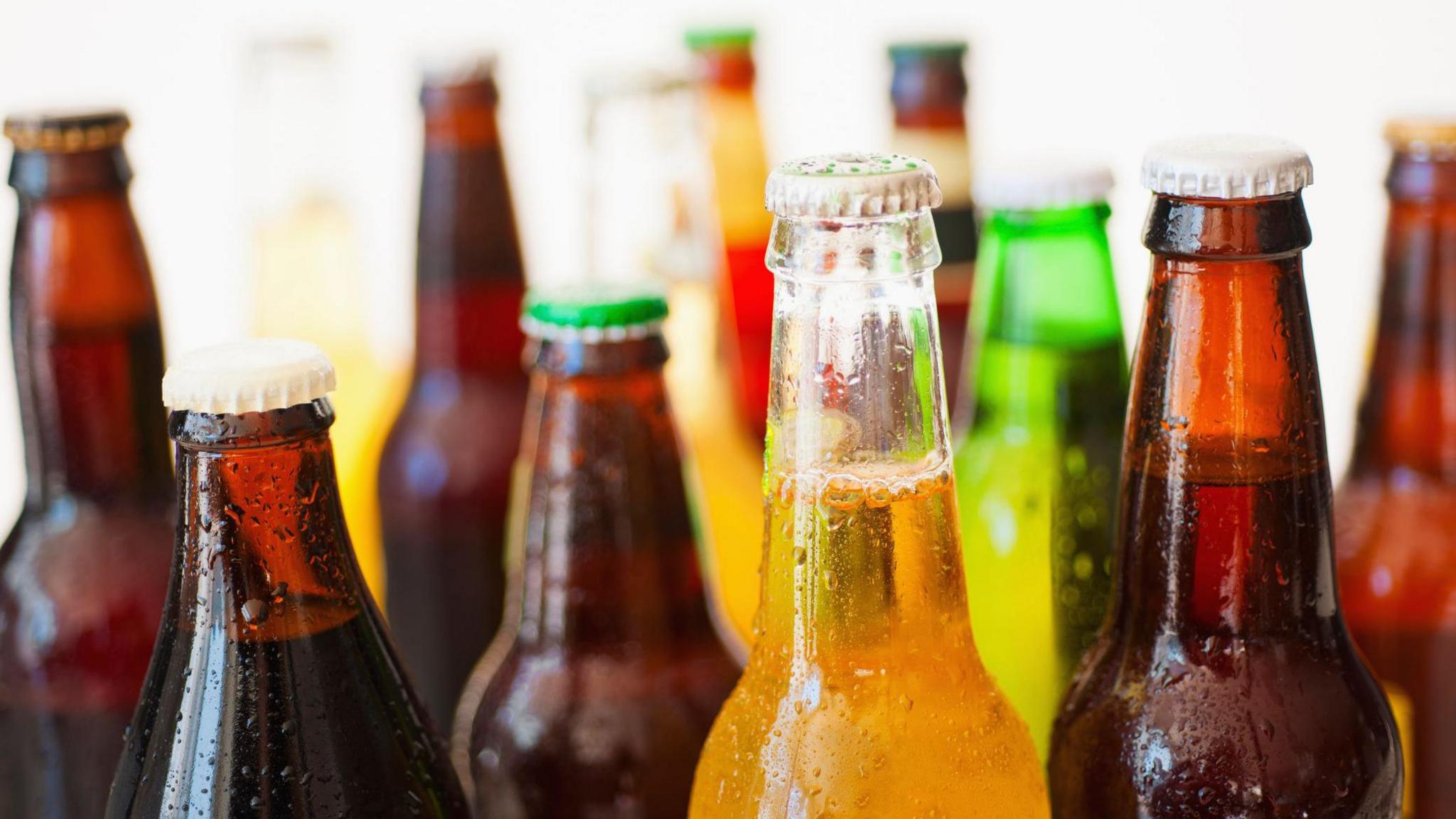 Different bottles of alcohol. The colours include brown and orange.