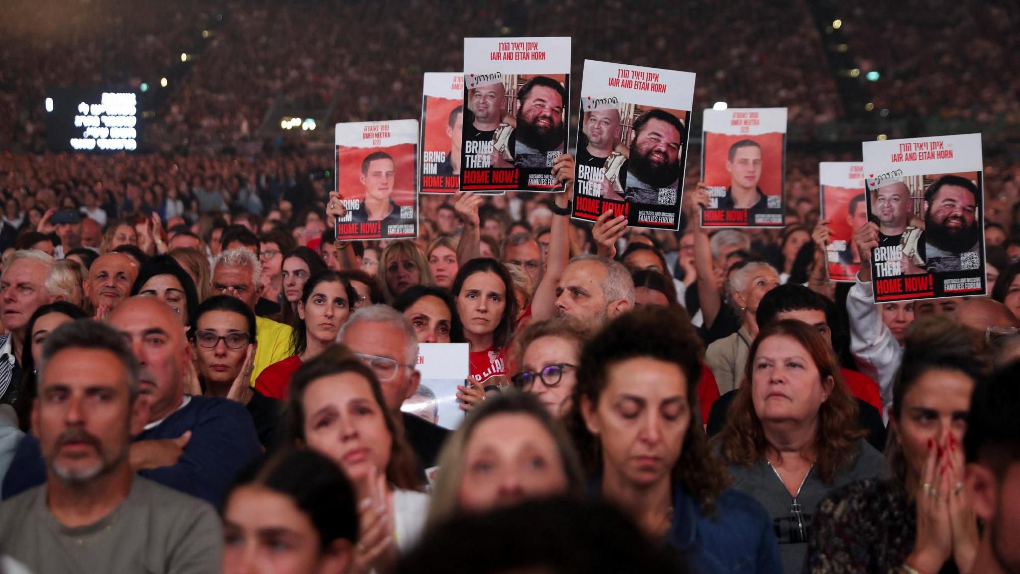 Israelis hold up posters calling for the release of hostages still held in Gaza, at a mass rally marking the second anniversary of the Hamas-led attack on Israel, in Tel Aviv, Israel (7 October 2025)
