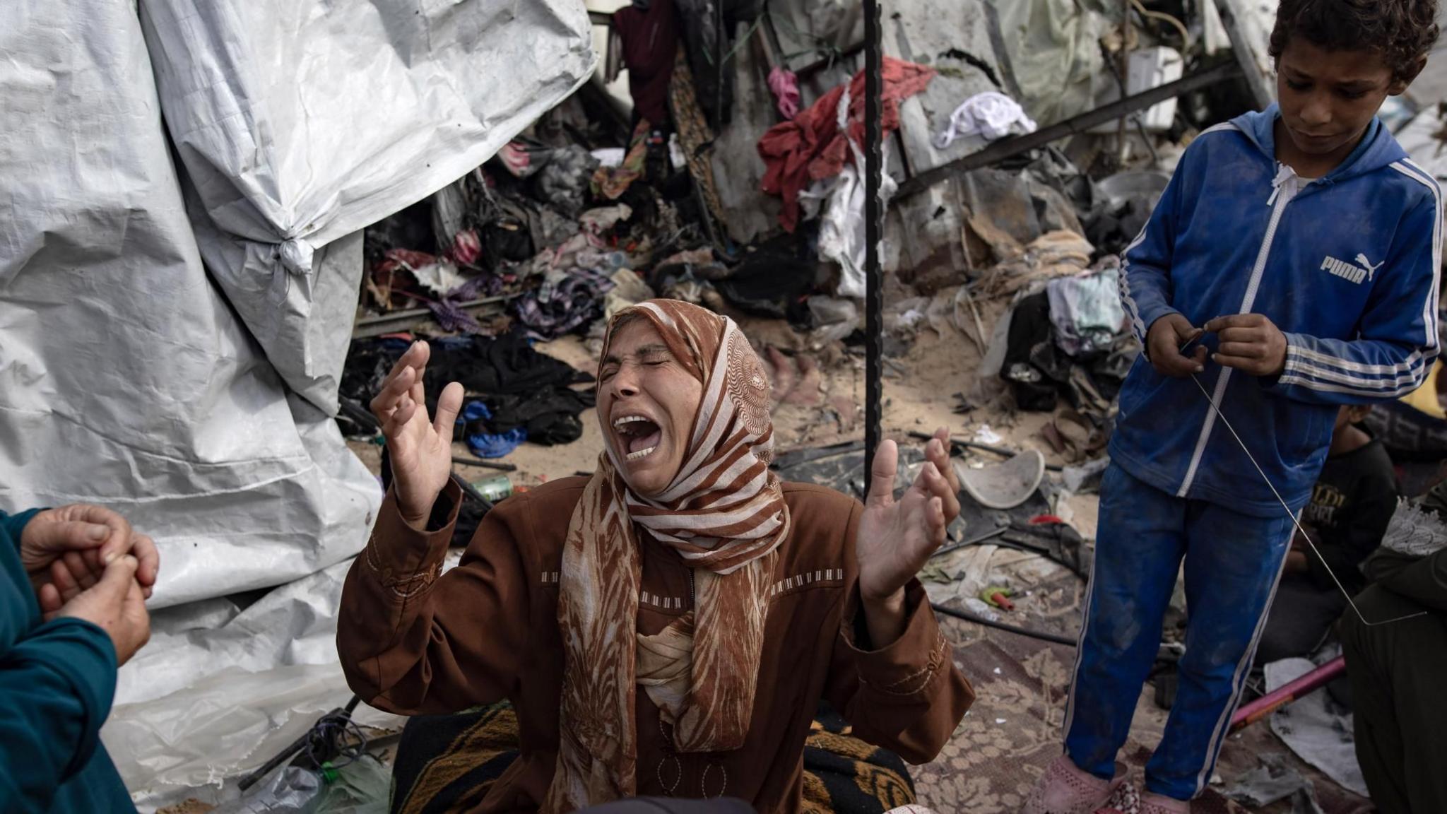 A Palestinian woman reacts next to tents destroyed by a fire triggered by an Israeli air strike in western Rafah on Sunday, in the southern Gaza Strip (28 May 2024)