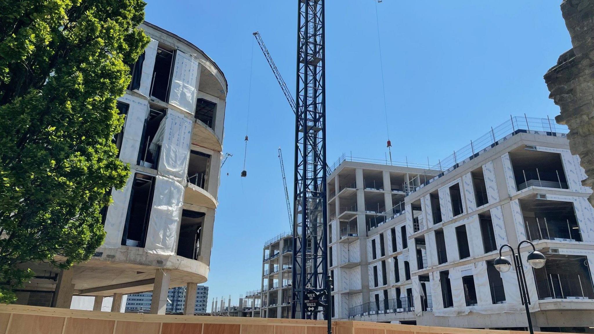 Half built buildings either side of a blue crane