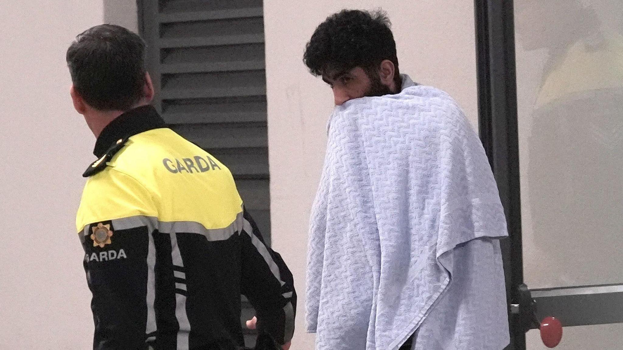 Mohammad Shaker Al Tamimi, who has black curly hair and a beard, is wrapped in a white towel