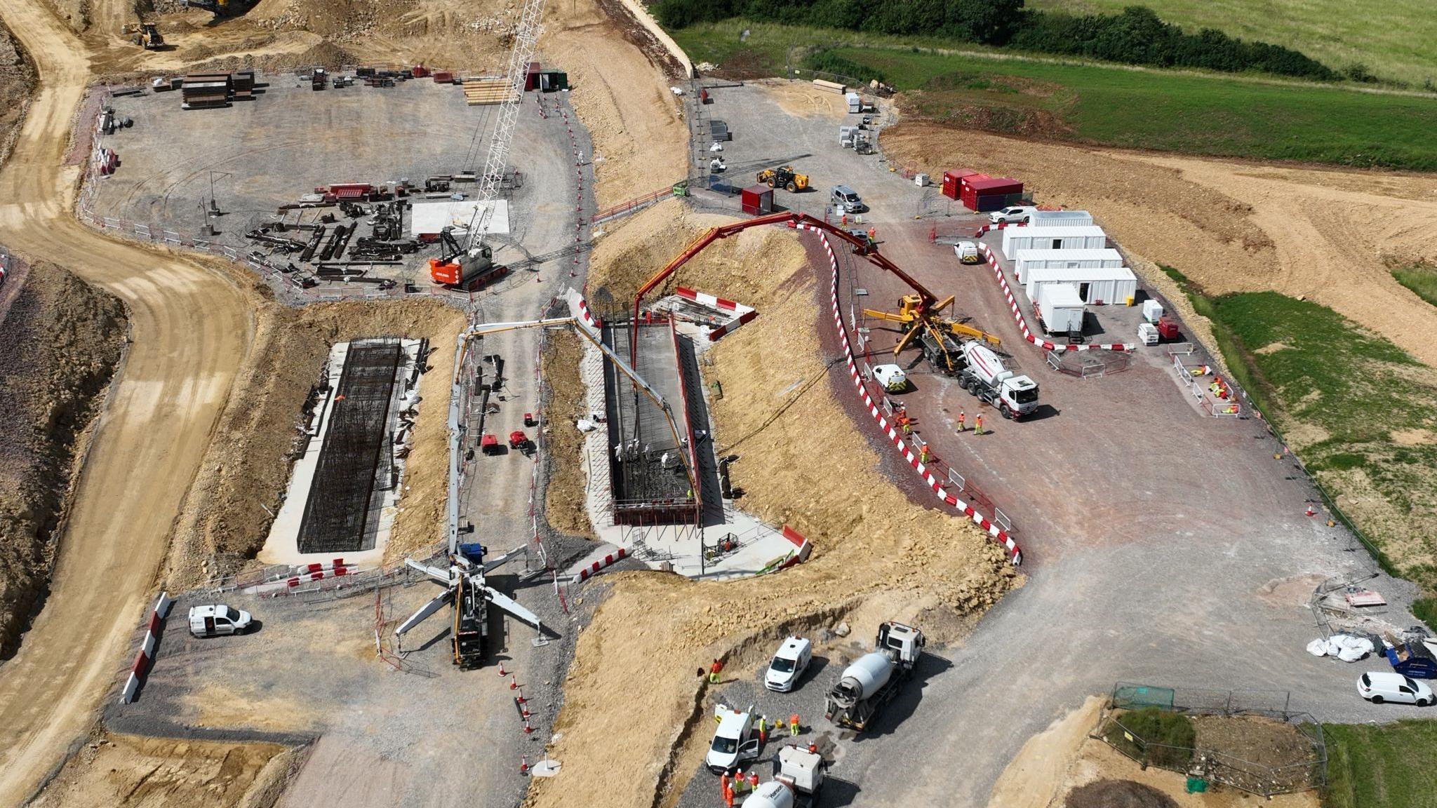 Concrete being poured at Shab Hill. There are a number of construction vehicles at the site.