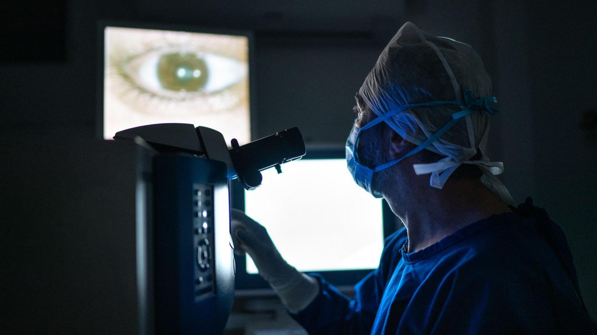 Doctor doing an exam or surgery, looking at images in monitor