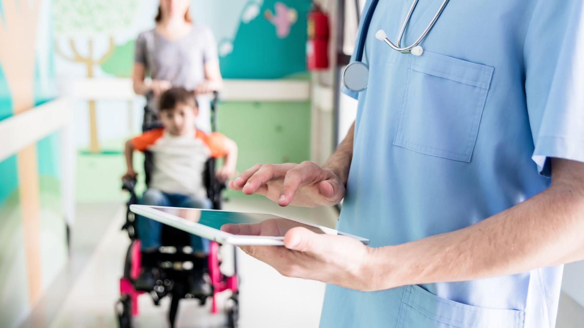 child in a wheelchair with Doctor looking at notes