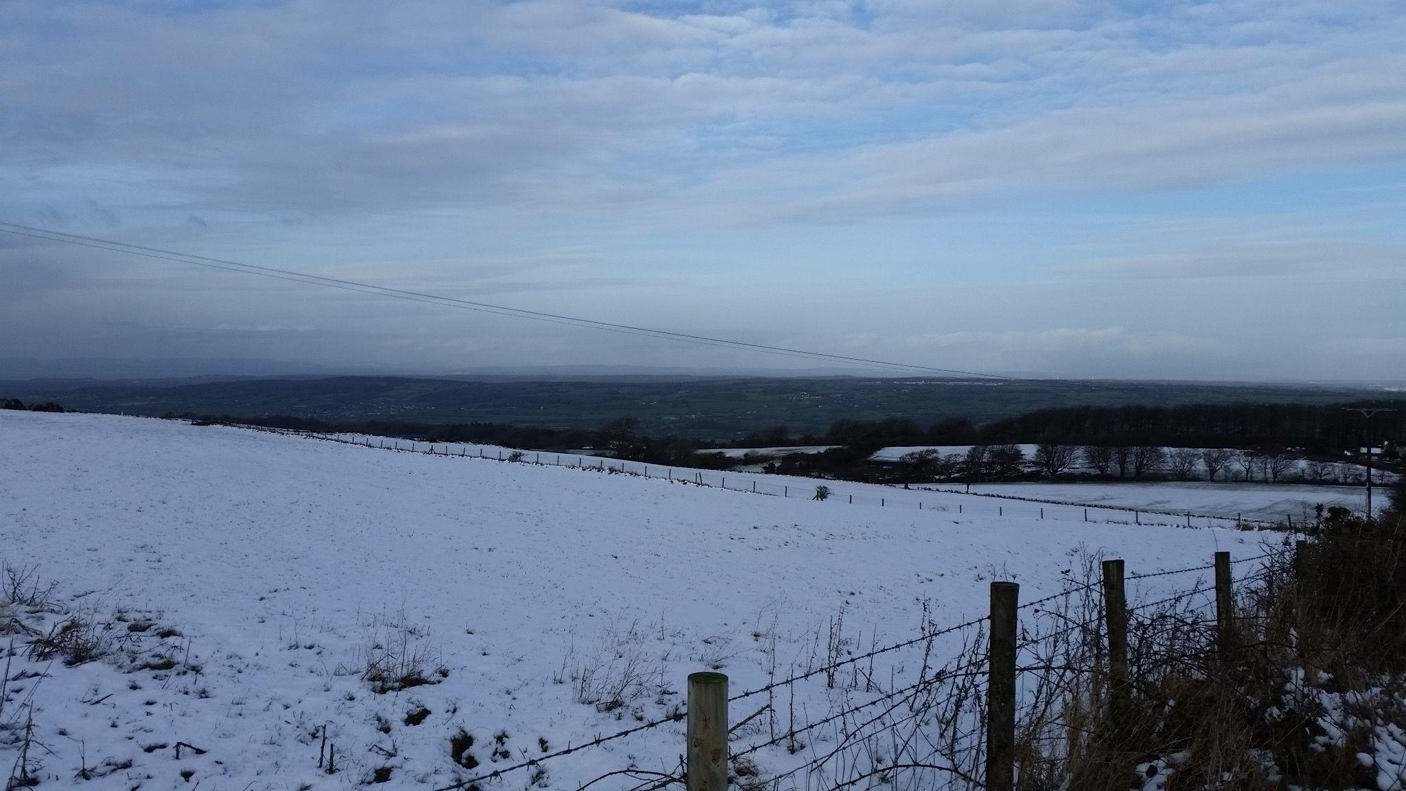 Snowy scenes on the Mendip Hills, with a barren, cold vista looking out to lower ground of North Somerset beyond, where no snow is visible. On this day in January 2015, snow only fell and settled on higher parts of the West Country.