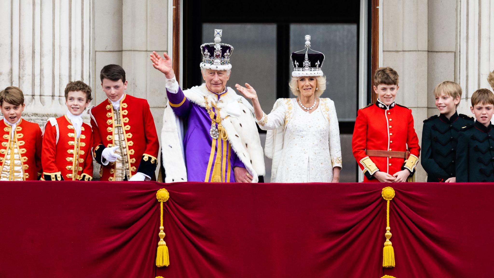 The King and Queen dressed in coronation robes appear on the Buckingham Palace balcony alongside pageboys - including the future king George. 