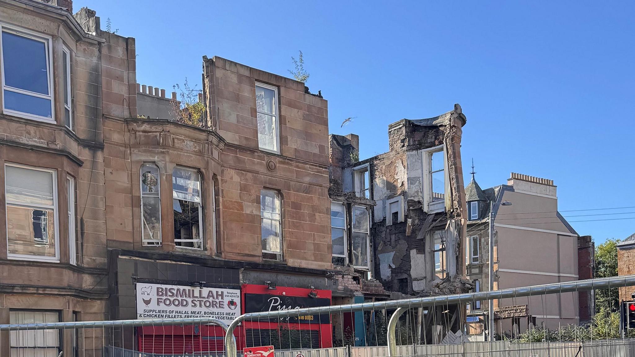A collapsed building with some storefronts