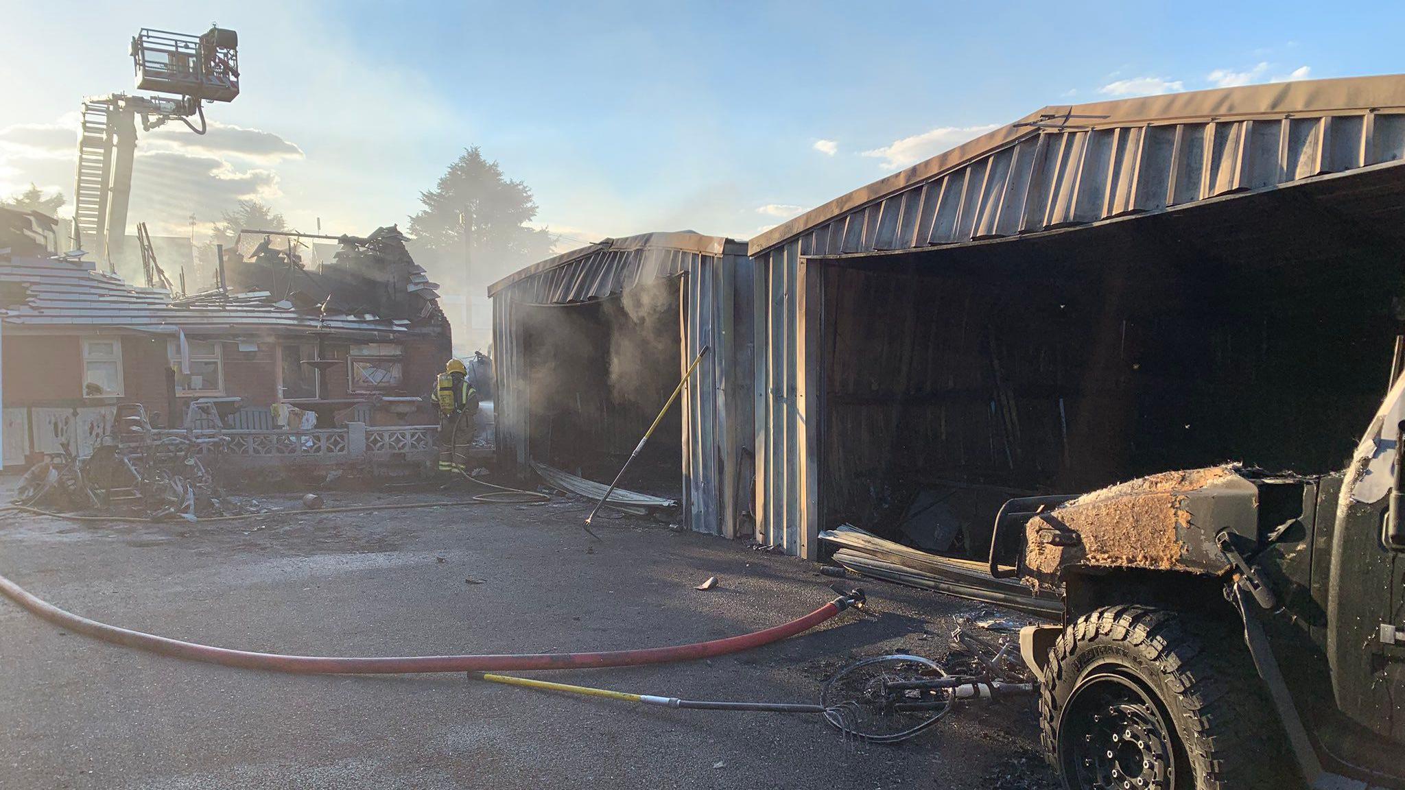 An image of smoke emerging from garages behind a bungalow which caught fire
