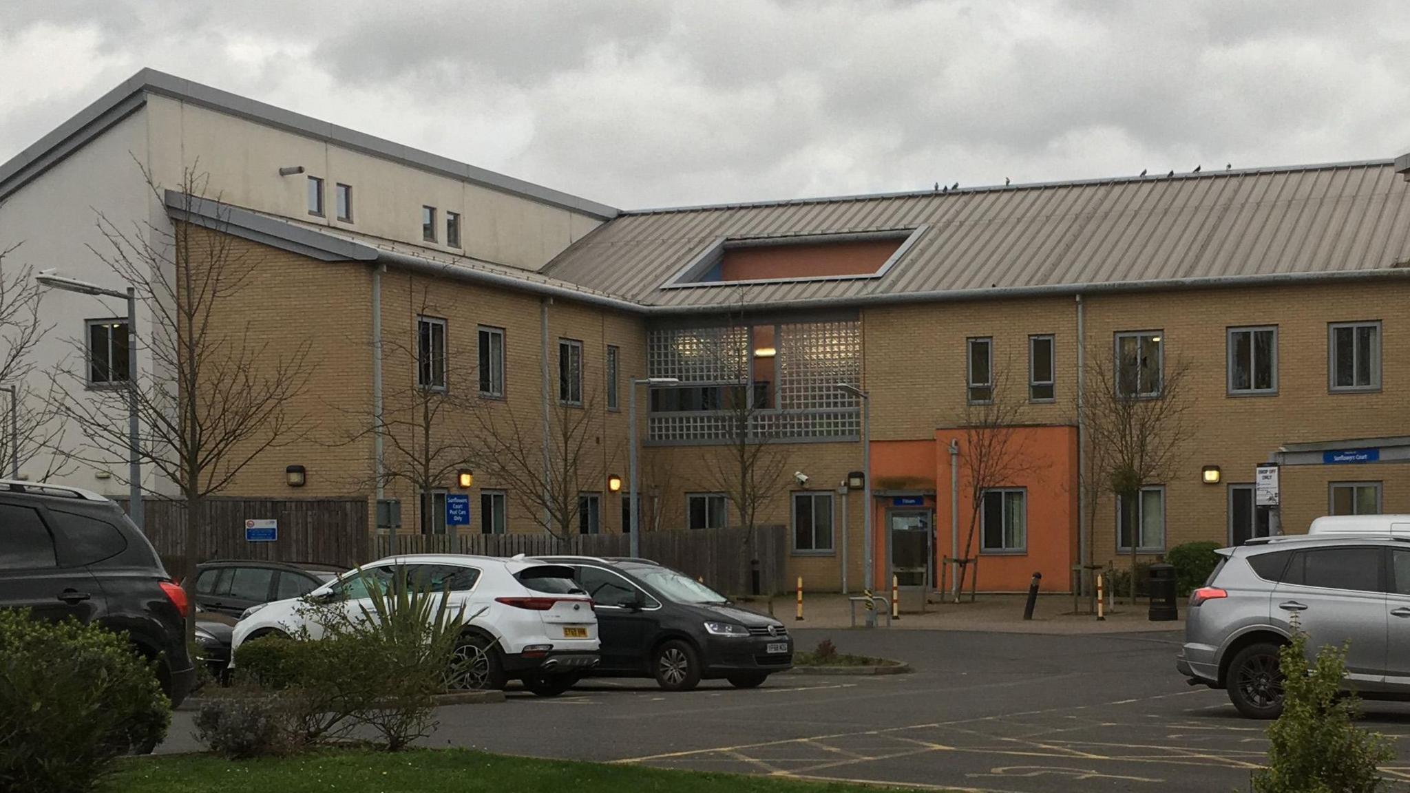 Goodmayes Hospital, a municipal-looking brick building with a car park