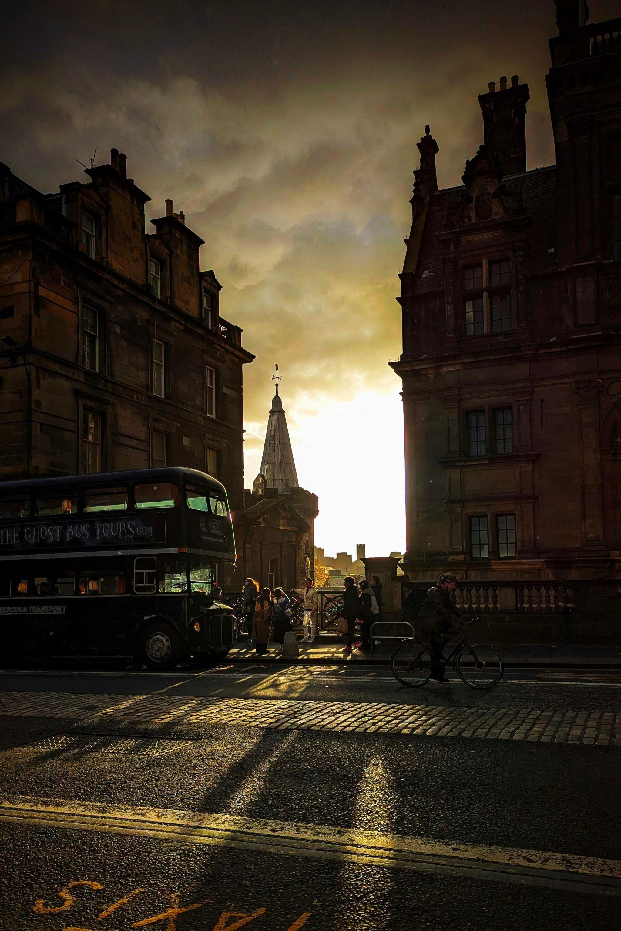 A chink of sunlight through a gap in buildings. The buildings are dark and silhouetted against this bright light. 