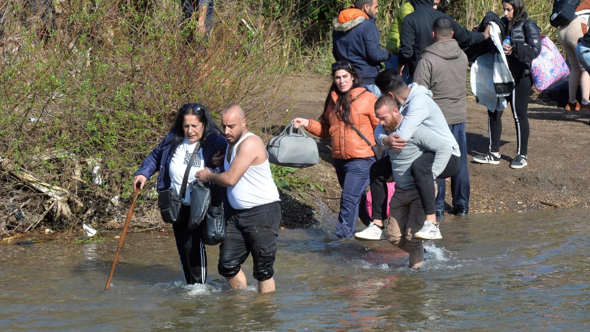 File photo showing Syrian Alawites fleeing sectarian attacks in Syria's coastal region crossing the Kabir river on the border between Syria and Lebanon, in village of Haker al-Dahri, northern Lebanon (11 March 2025)