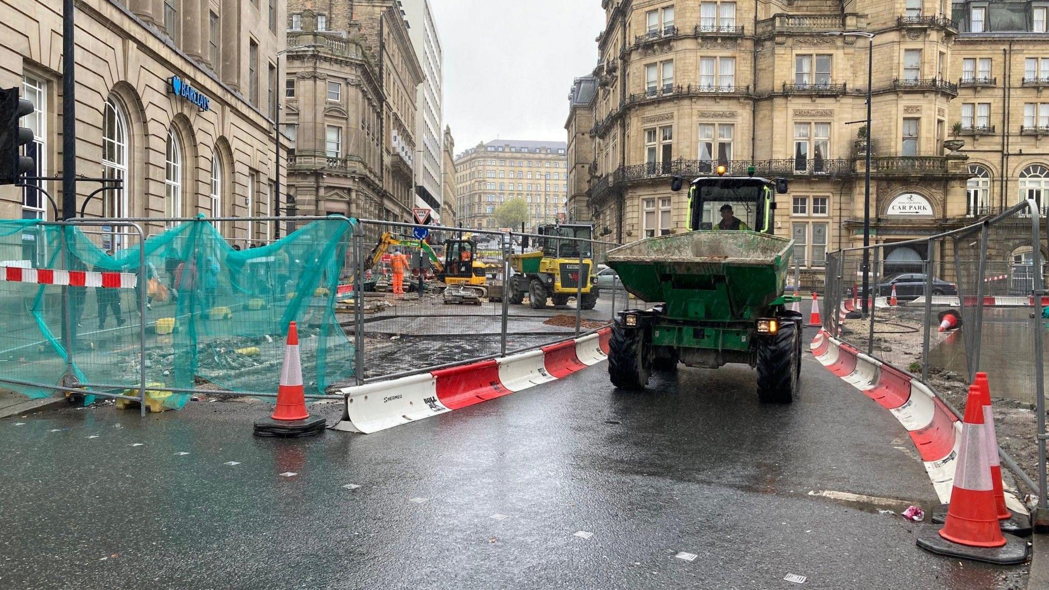 A dumper truck is driving down Market Street in Bradford