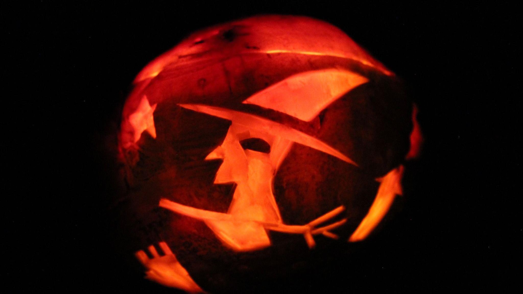 A large turnip, which has a witch carved on it, as well as a star. It has a light inside so it glows orange against the darkness.