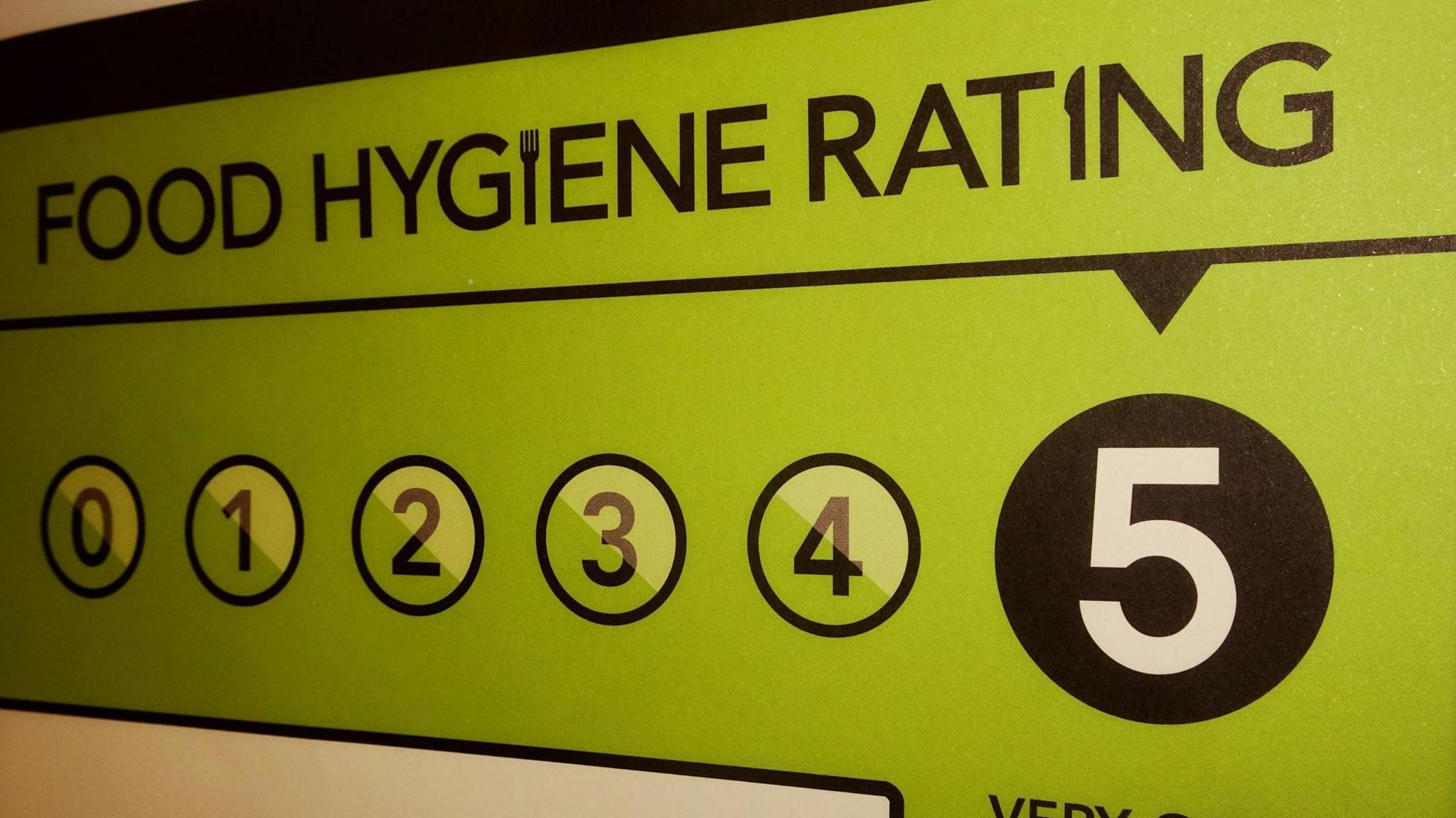 Green food hygiene rating sign numbered 0-5