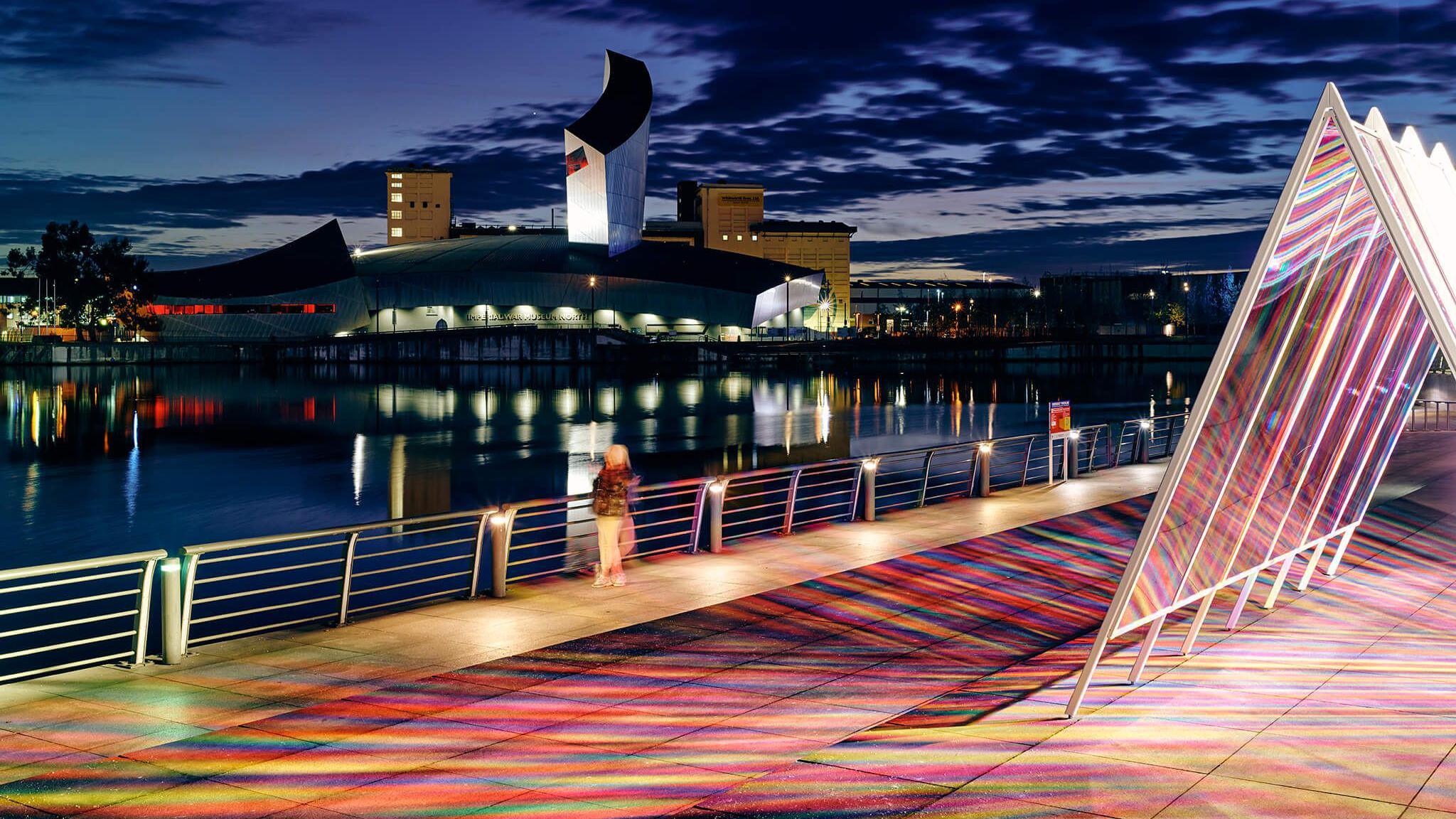 City skyline with a triangle, glowing art feature on the bridge. 