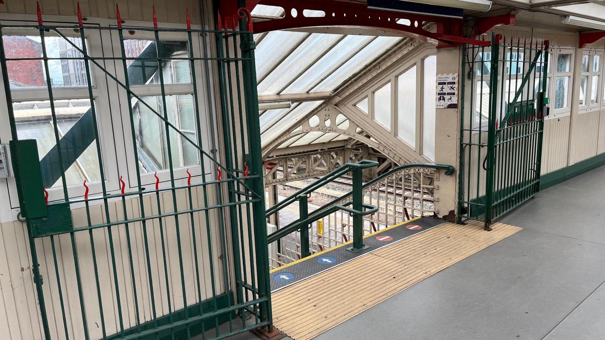 View from the bridge towards one of the staircases to platforms, showing large metal gates in an open position