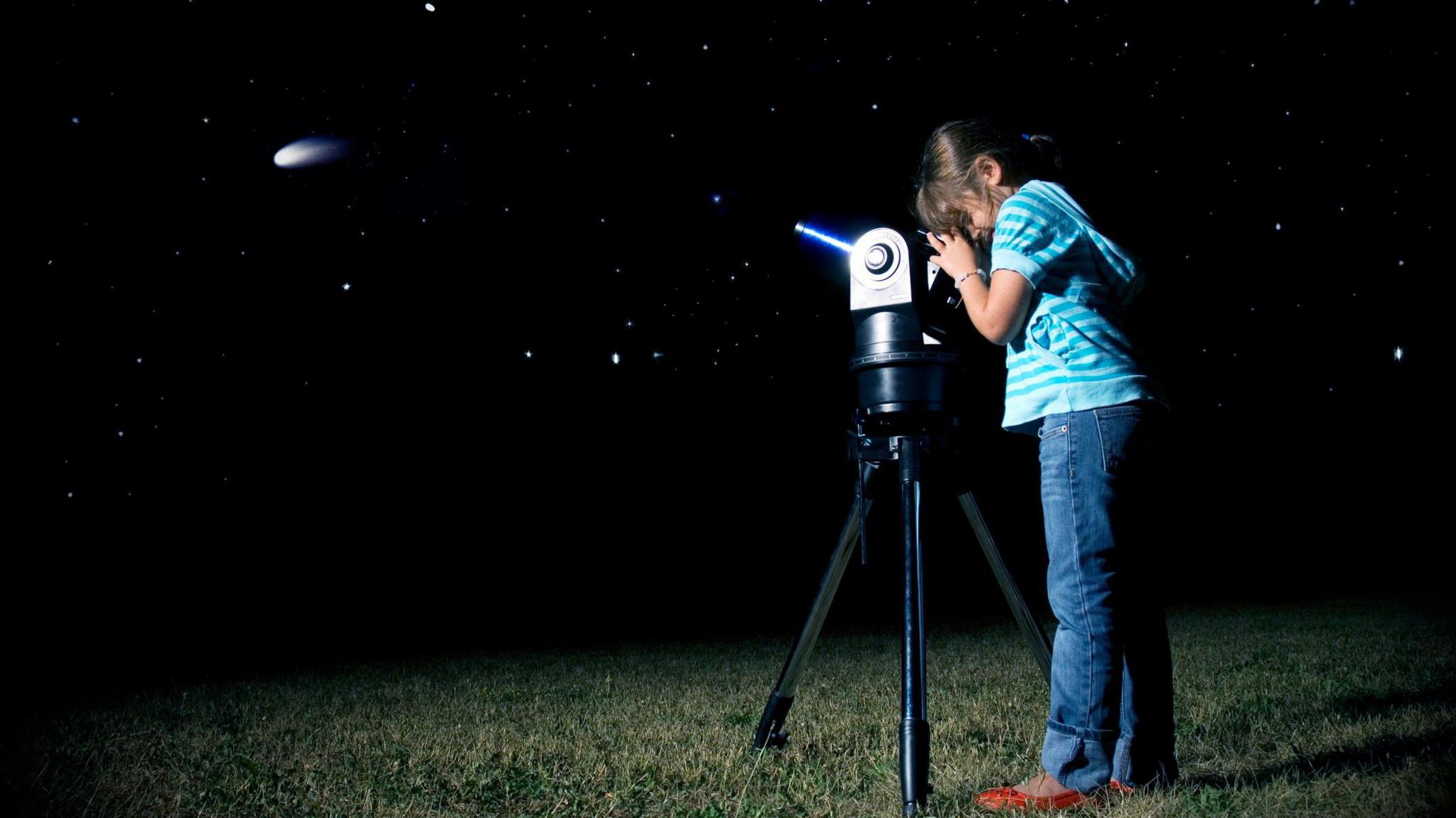 Child looking through a telescope at a comet