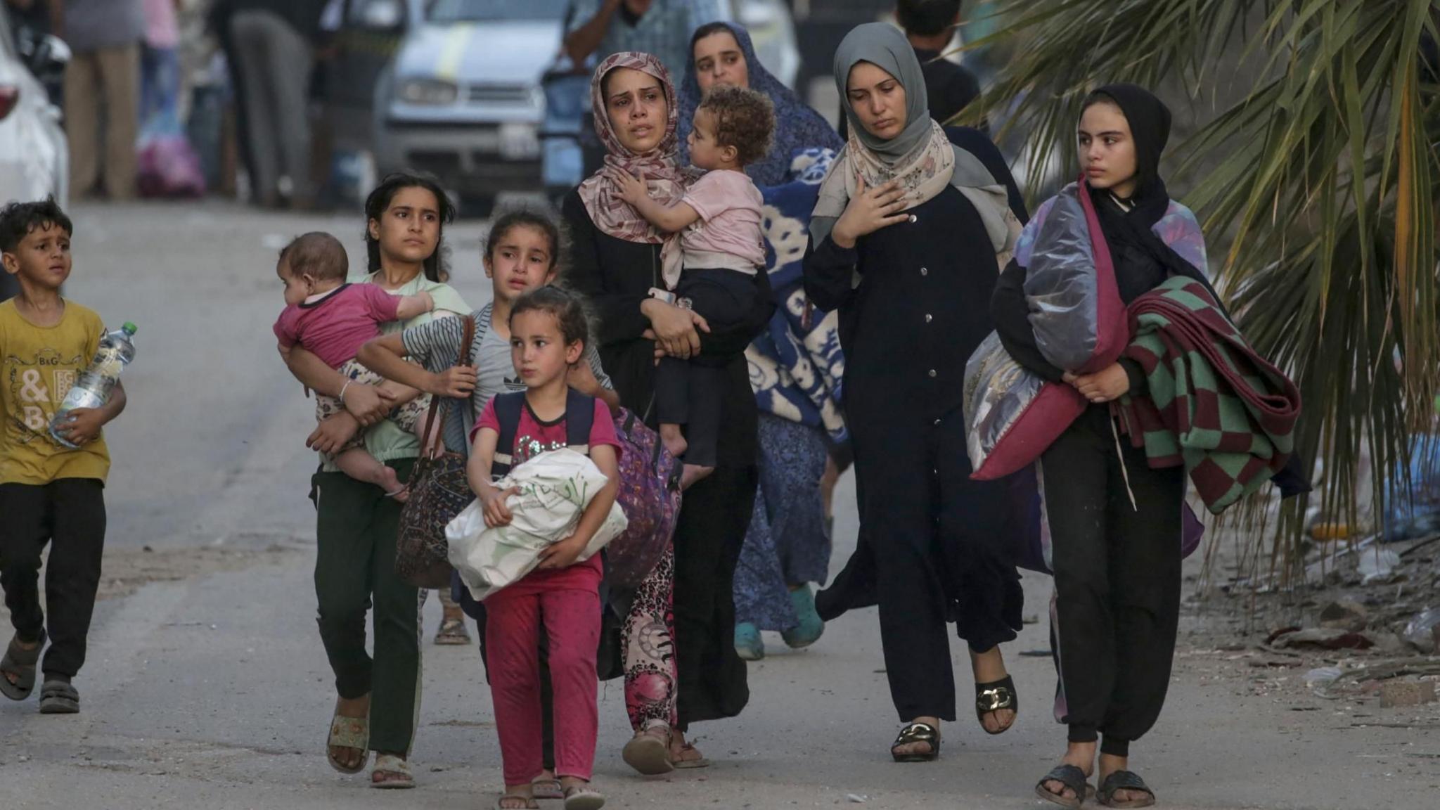 Displaced Palestinians flee Bureij refugee camp, in the central Gaza Strip, following the start of an Israeli military ground operation 