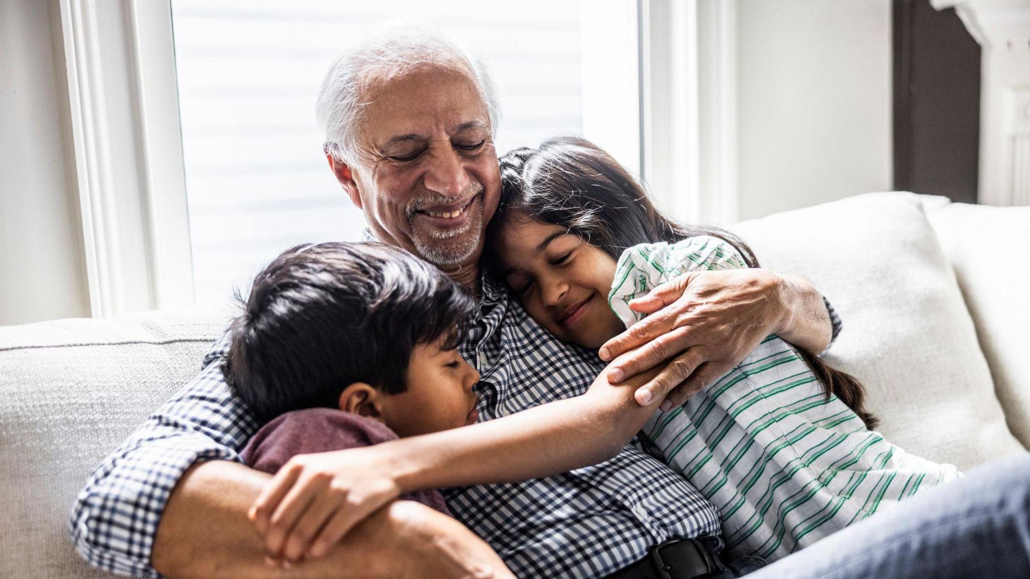 Grandfather hugging grandchildren.