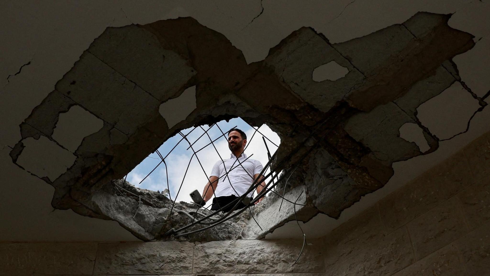 A man surveys damage to a building in Israel following a Hezbollah rocket and drone attack (25 August 2024)