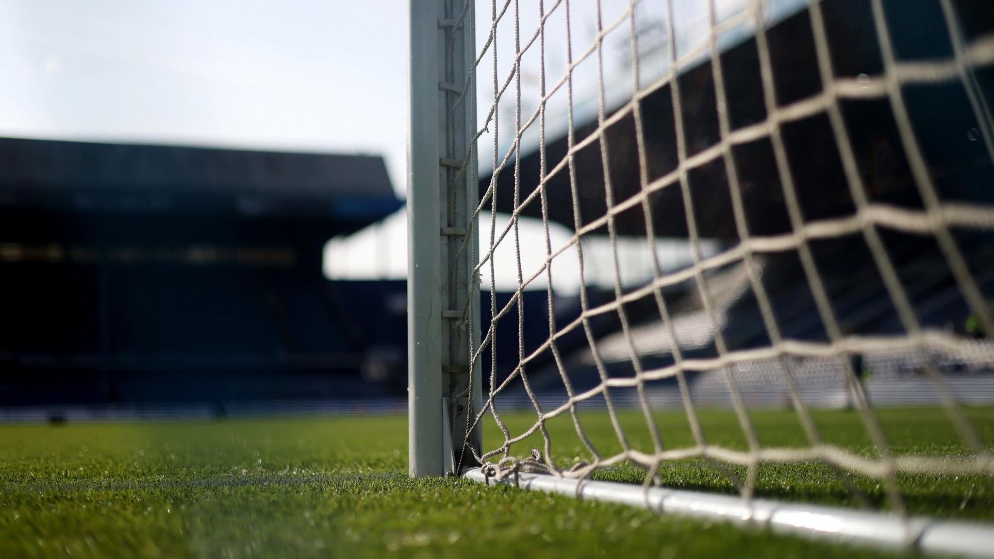 Pitch-level view of the goalpost and netting