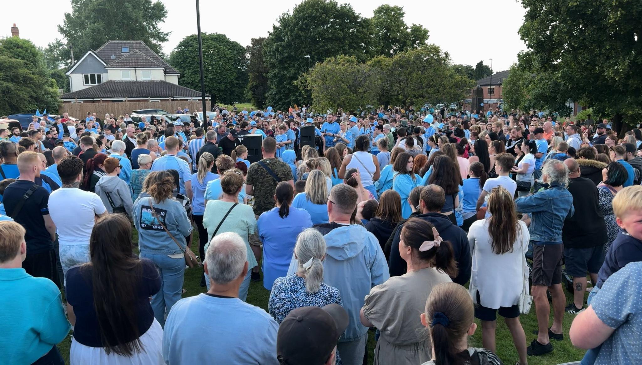 Crowd gathered for the balloon release, many wearing sky blue