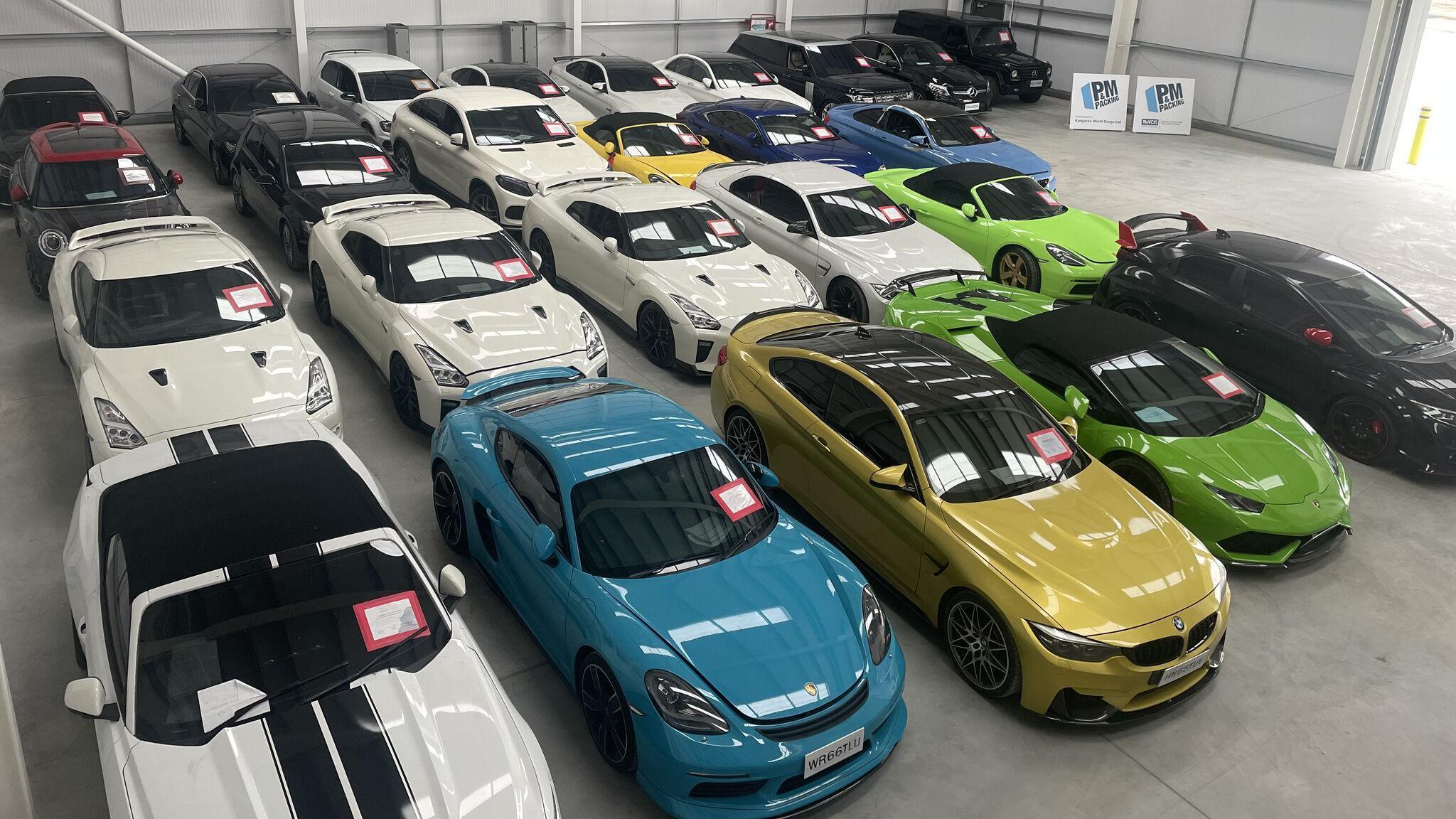 A view from a high vantage point of 25 high-value cars inside a warehouse