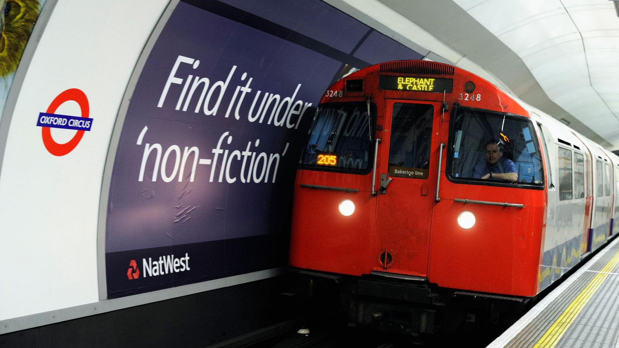 Underground train entering Oxford Circus Tube station with driver visible