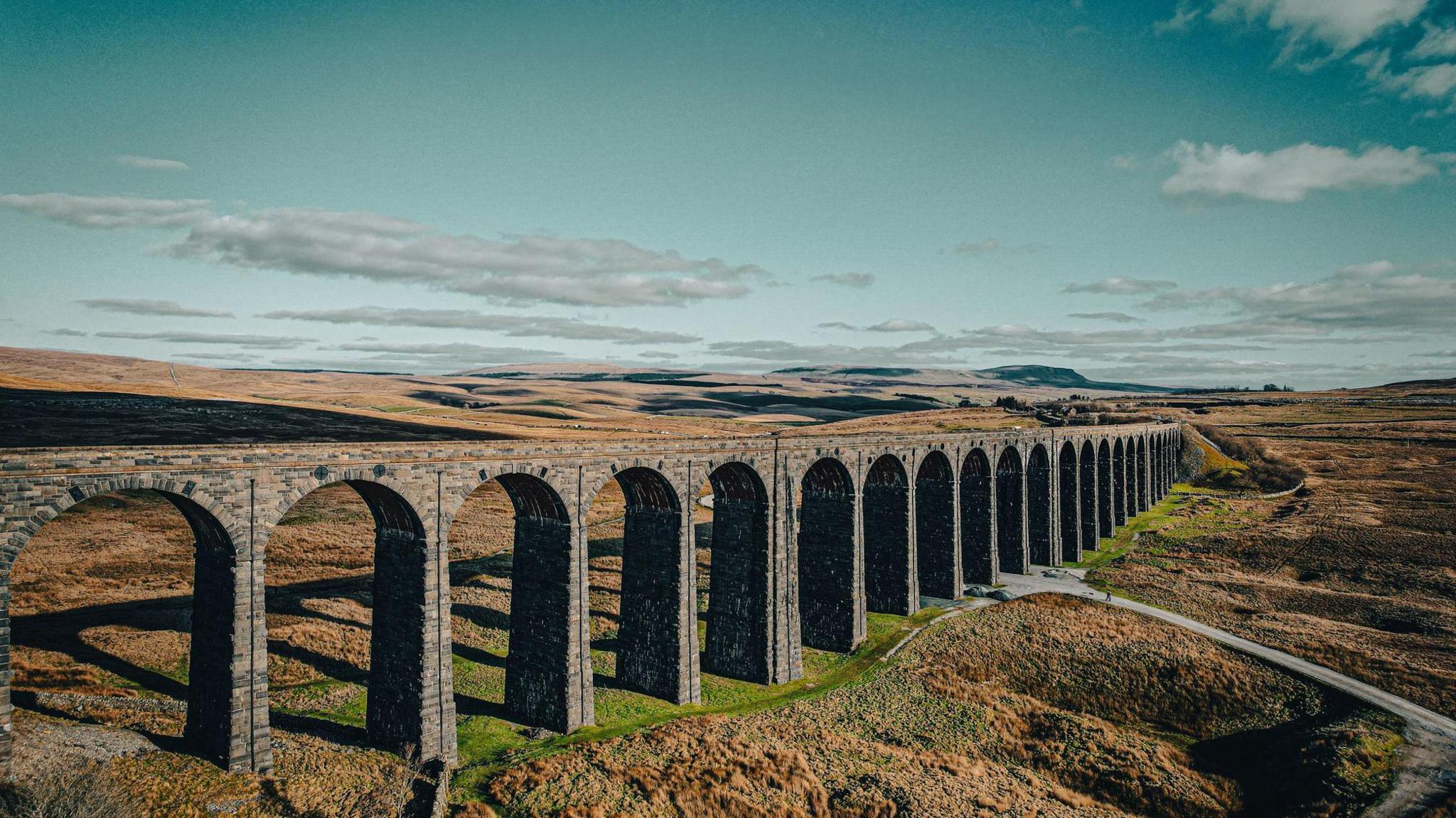Image shows the Ribblehead Viaduct - which carries the Settle to Carlisle railway line across the valley below