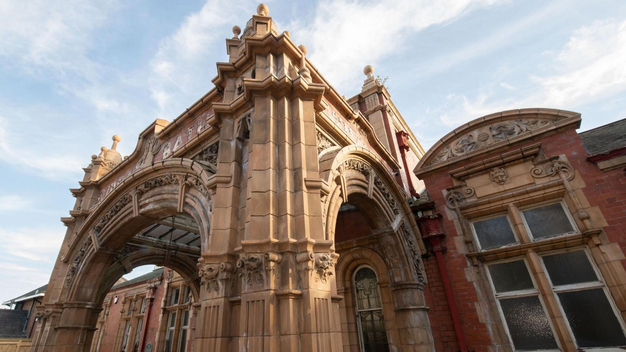 An ornate sandstone and red brick swimming pool building