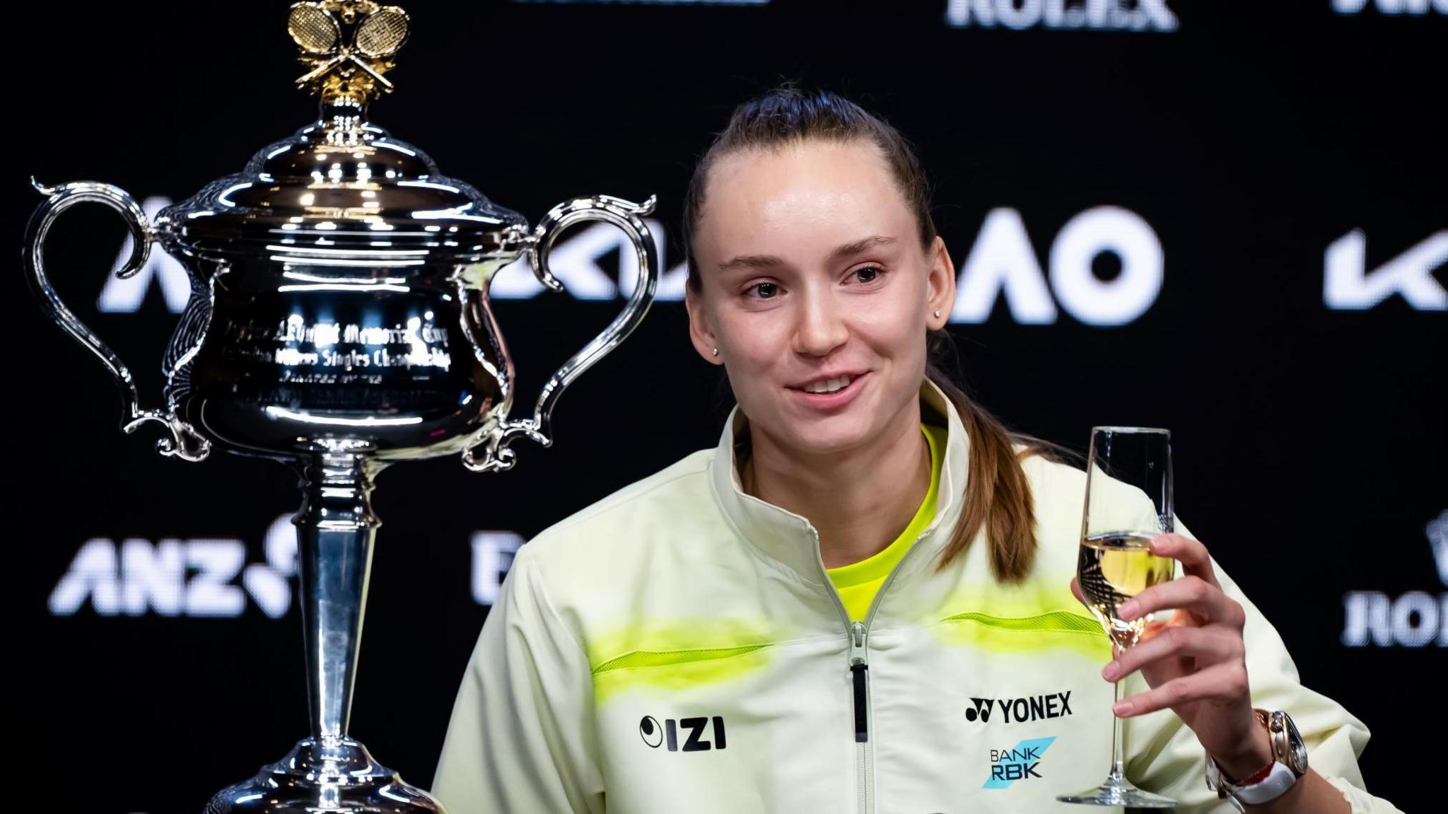 Elena Rybakina drinks champagne at her news conference after winning the Australian Open