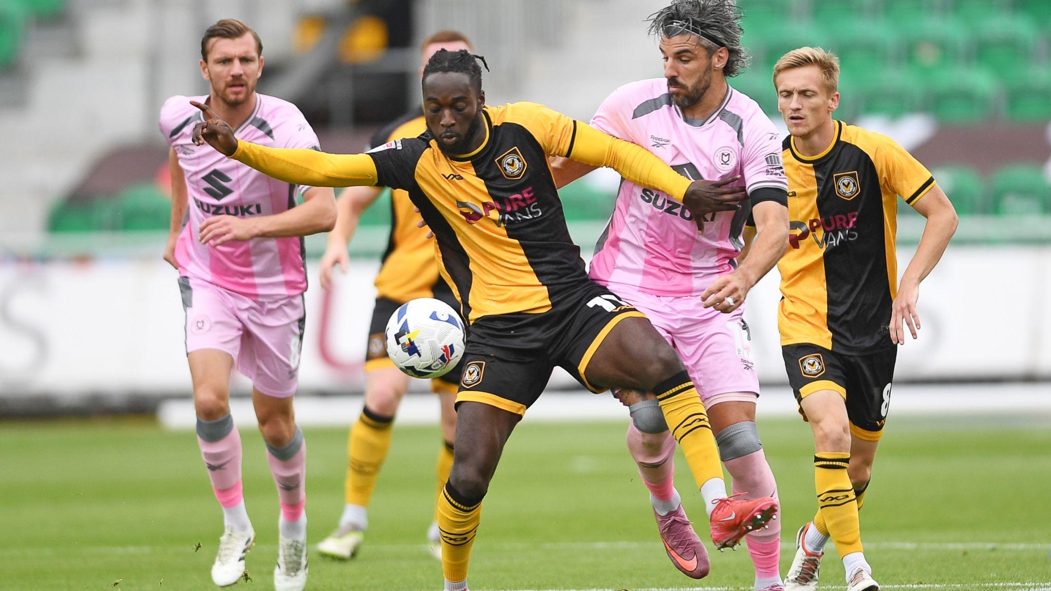 Cameron Antwi of Newport County is challenged by Callum Paterson of MK Dons