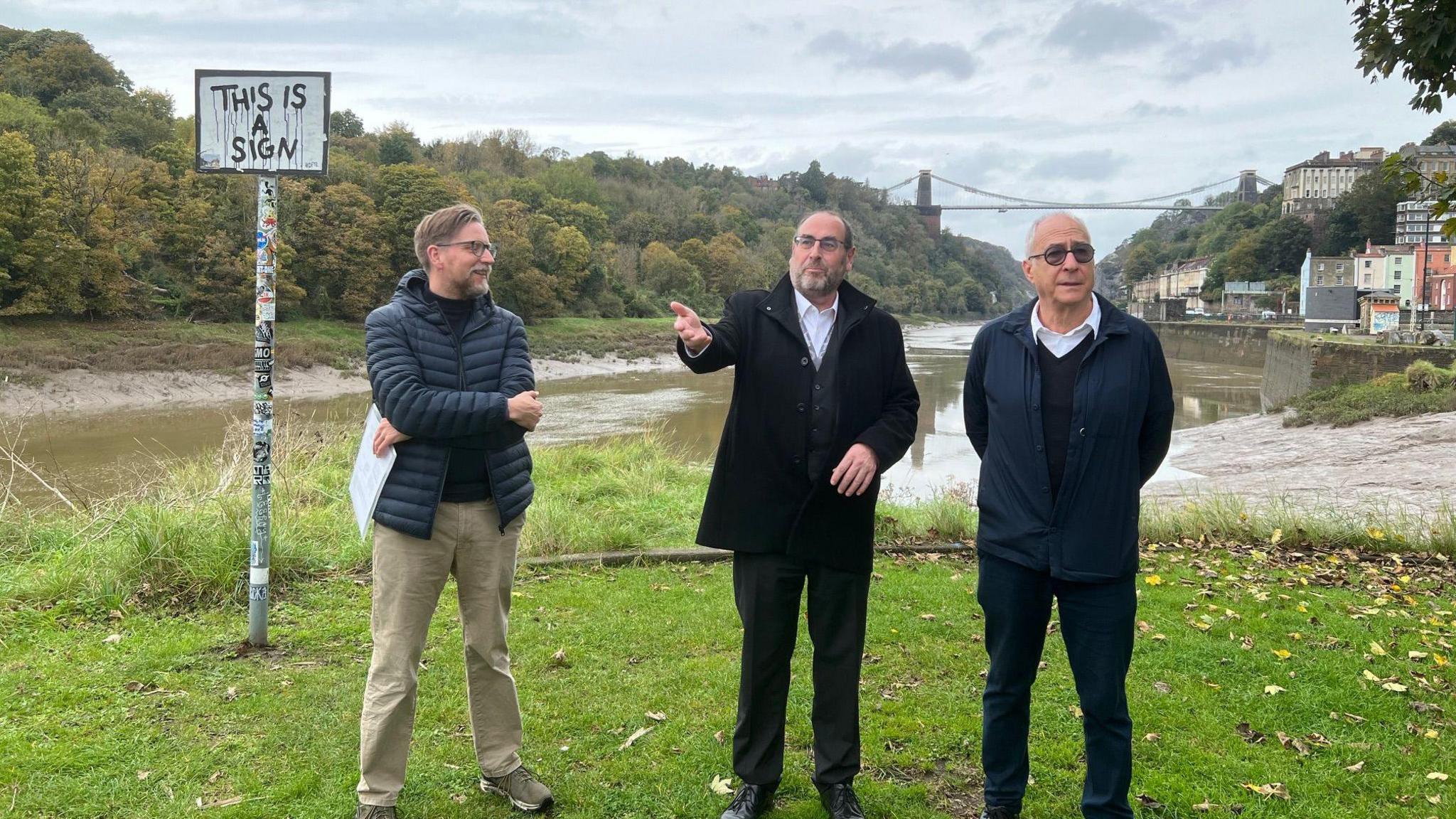 Council leader Tony Dyer and two designers standing near the Western Harbour site with the Clifton Suspension Bridge in the background