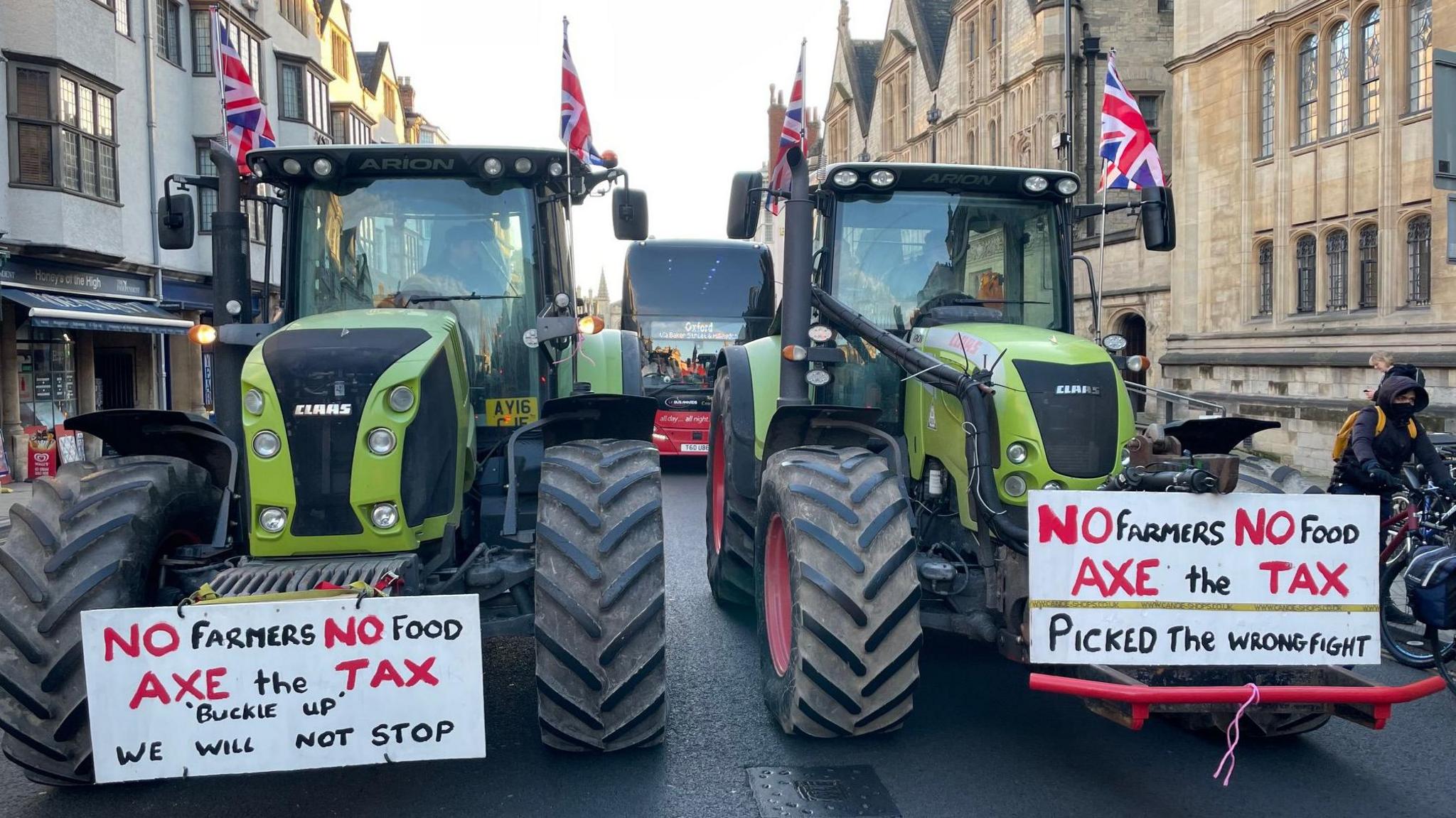 Two tractors with union flags attached to their cabs, and displaying signs reading No Farmers, No Food are pictured side-by-side in Oxford