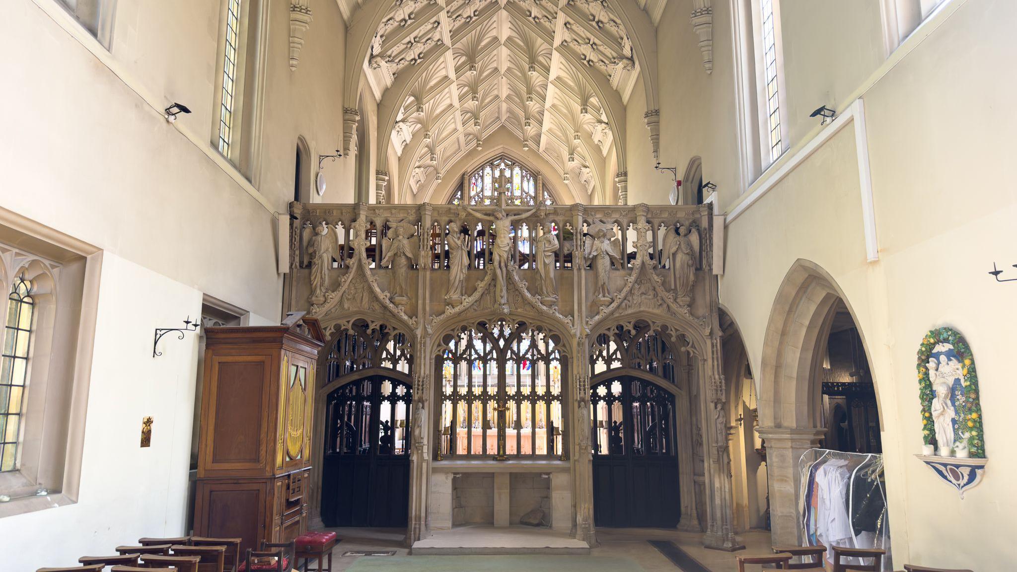 A small chapel with white walls and a stone depiction of Christ on the cross.