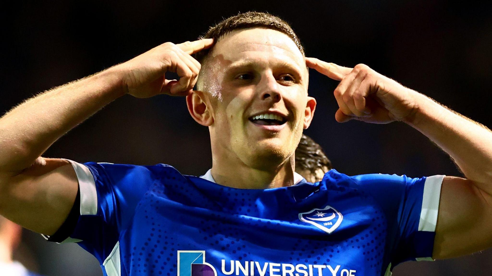 Colby Bishop points to his temples after scoring Portmouth's second goal against Ipswich
