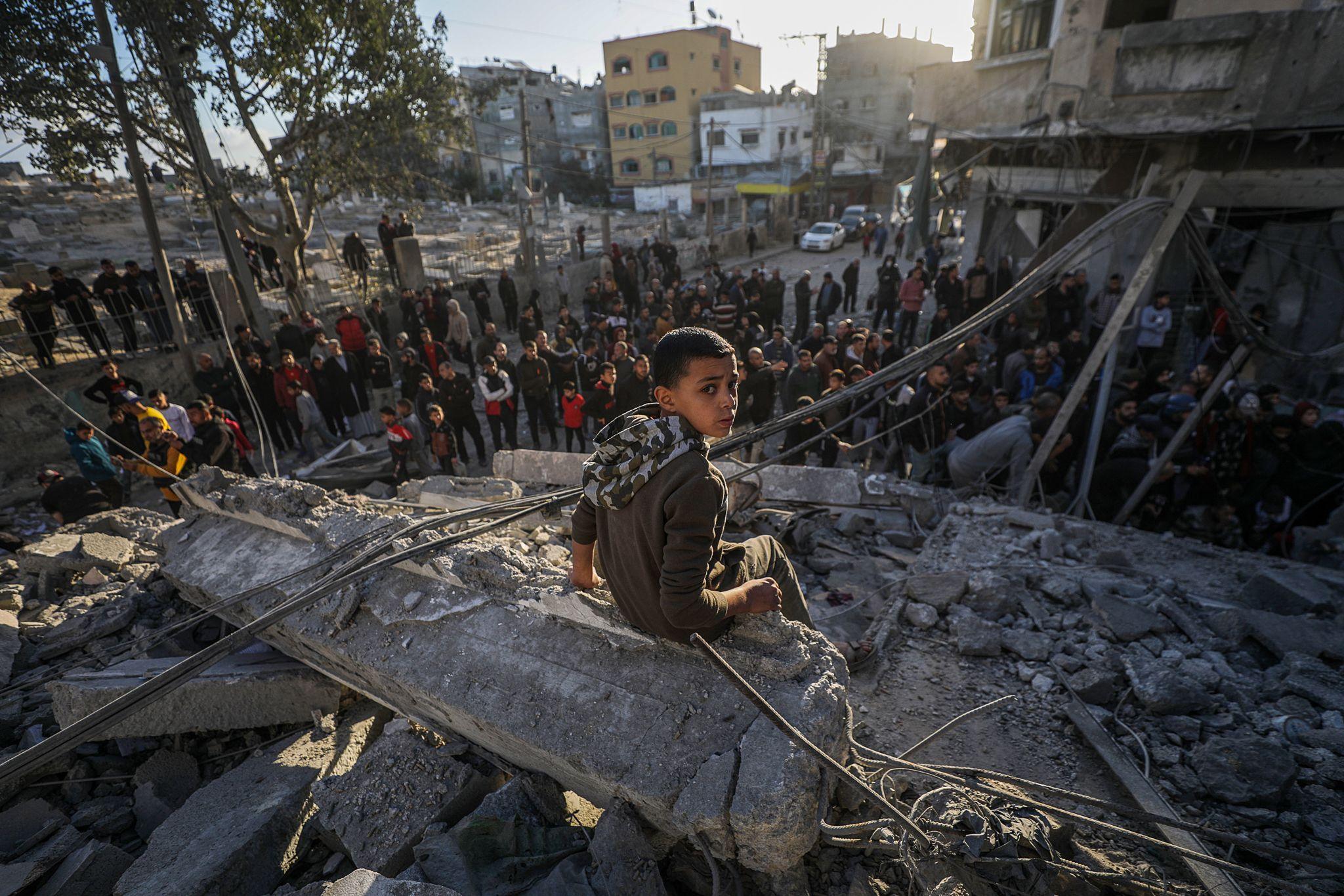 A Palestinian boy sits on rubble following Israeli airstrikes on Al Nuseirat refugee camp, central Gaza