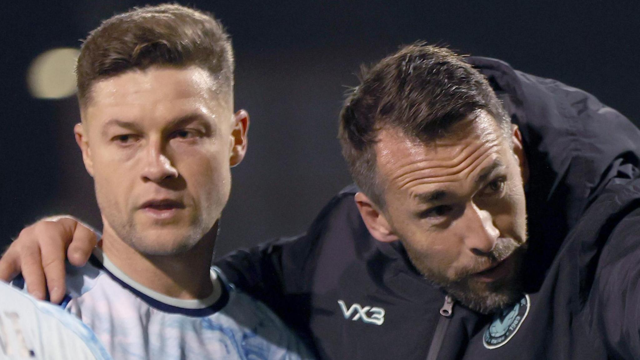 Newport manager Christian Fuchs and James Clarke of Newport point to fans