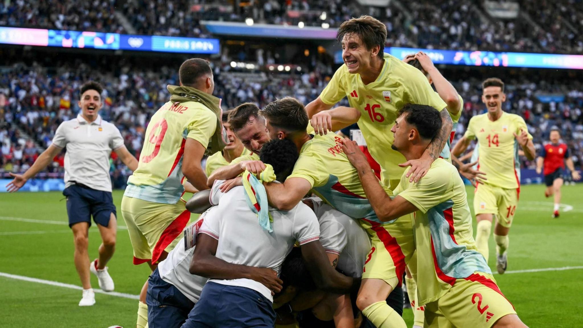 Spain players and staff mob winning goalscorer Sergio Camello