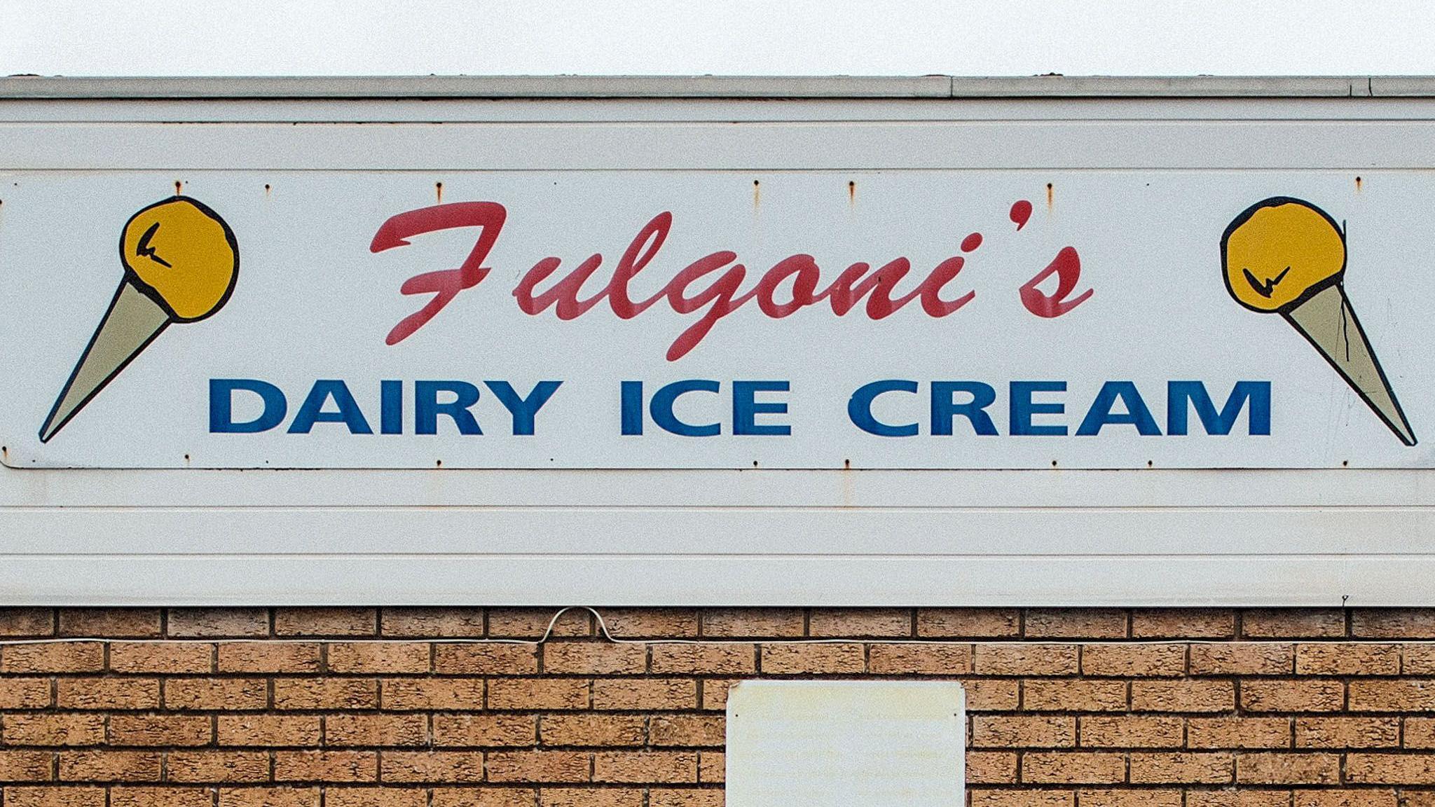 Photo of an ice cream sign, with yellow cones saying Fulgoni's dairy ice cream