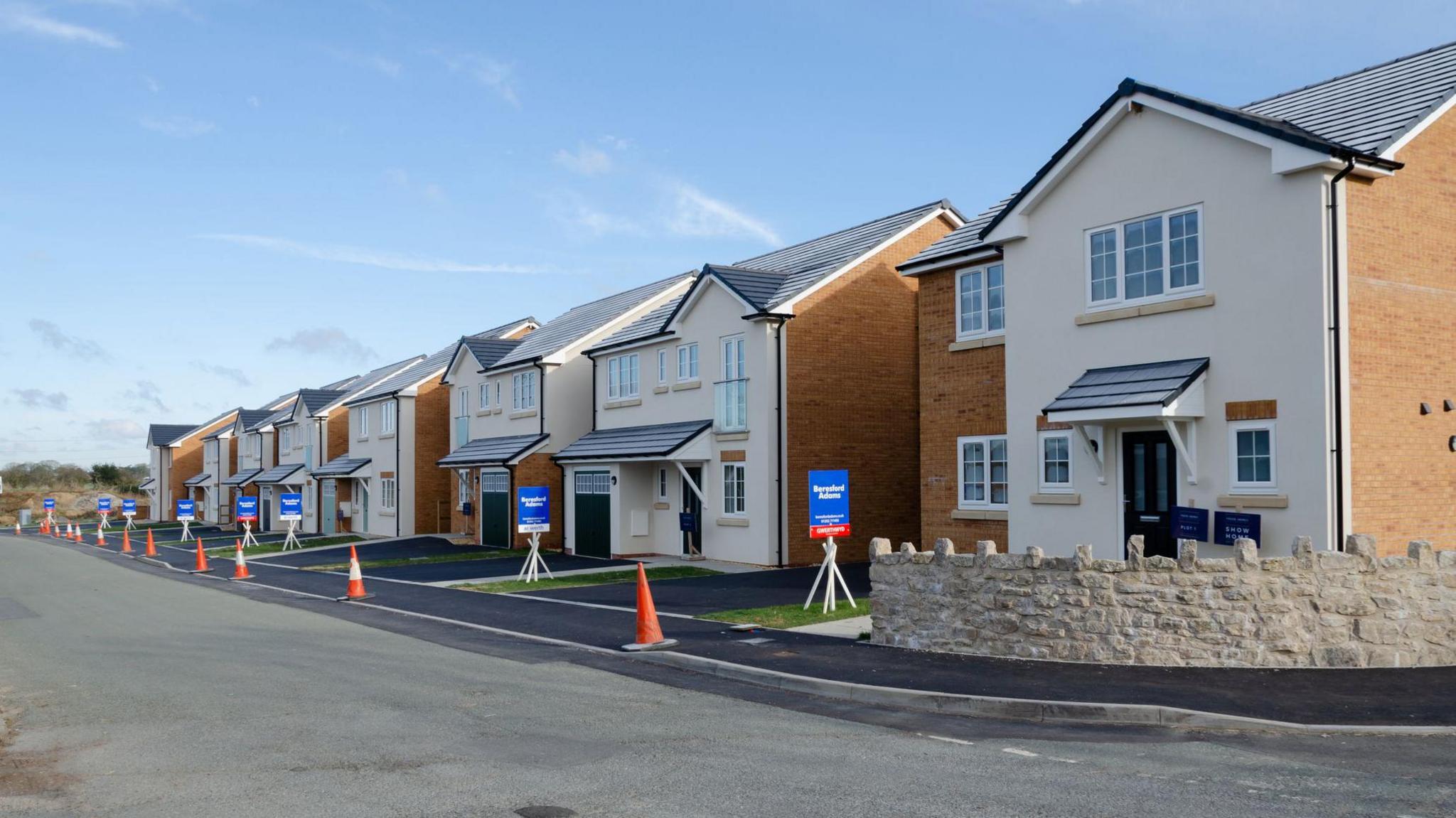 Caerwys, Flintshire; UK: Feb 11, 2021: New built detached homes with a line of estate agent sale boards on the village outskirts are being marketed by Beresford Adams Estate Agents