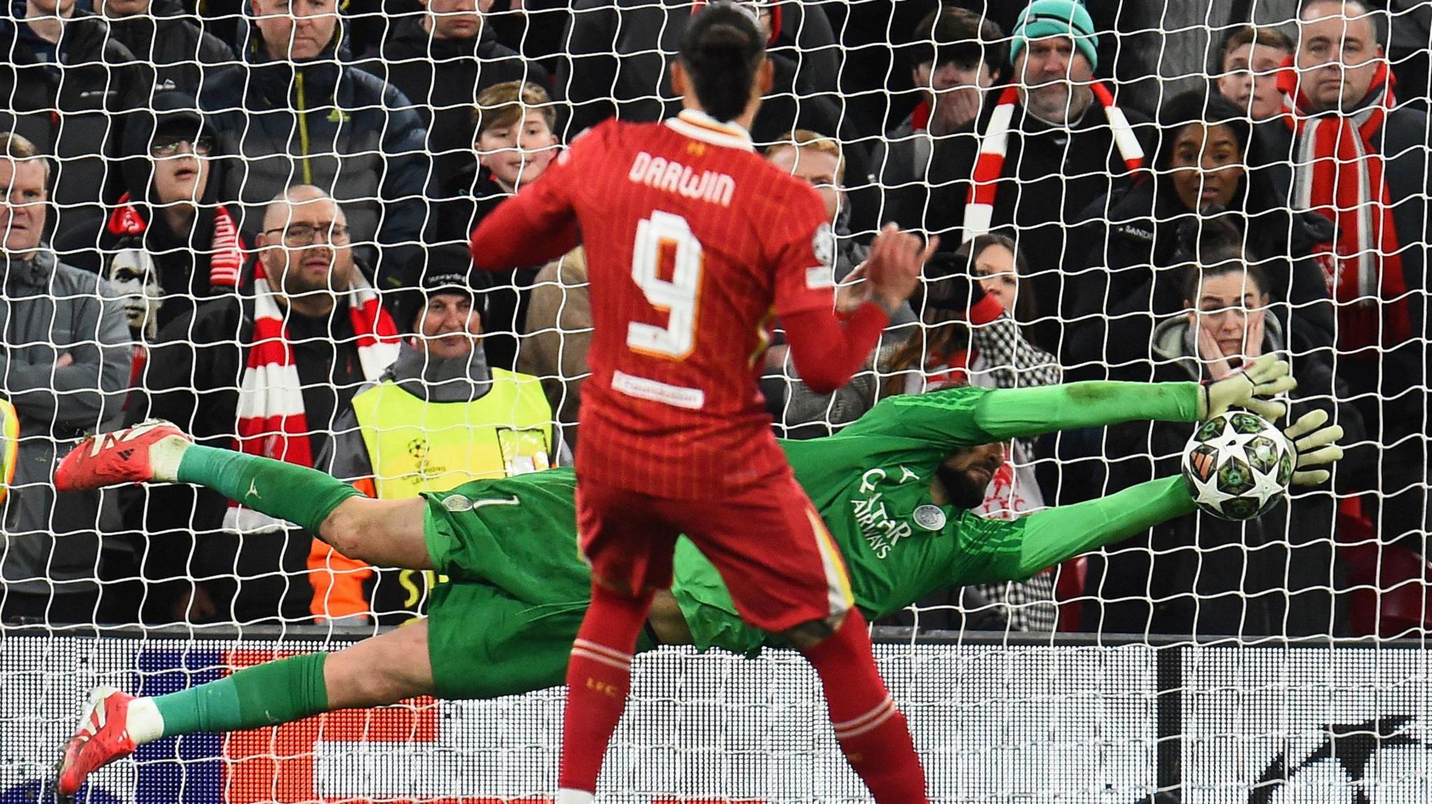 PSG keeper Gianluigi Donnarumma, wearing all green, saves the penalty from Darwin Nunez (in a red Liverpool kit). 